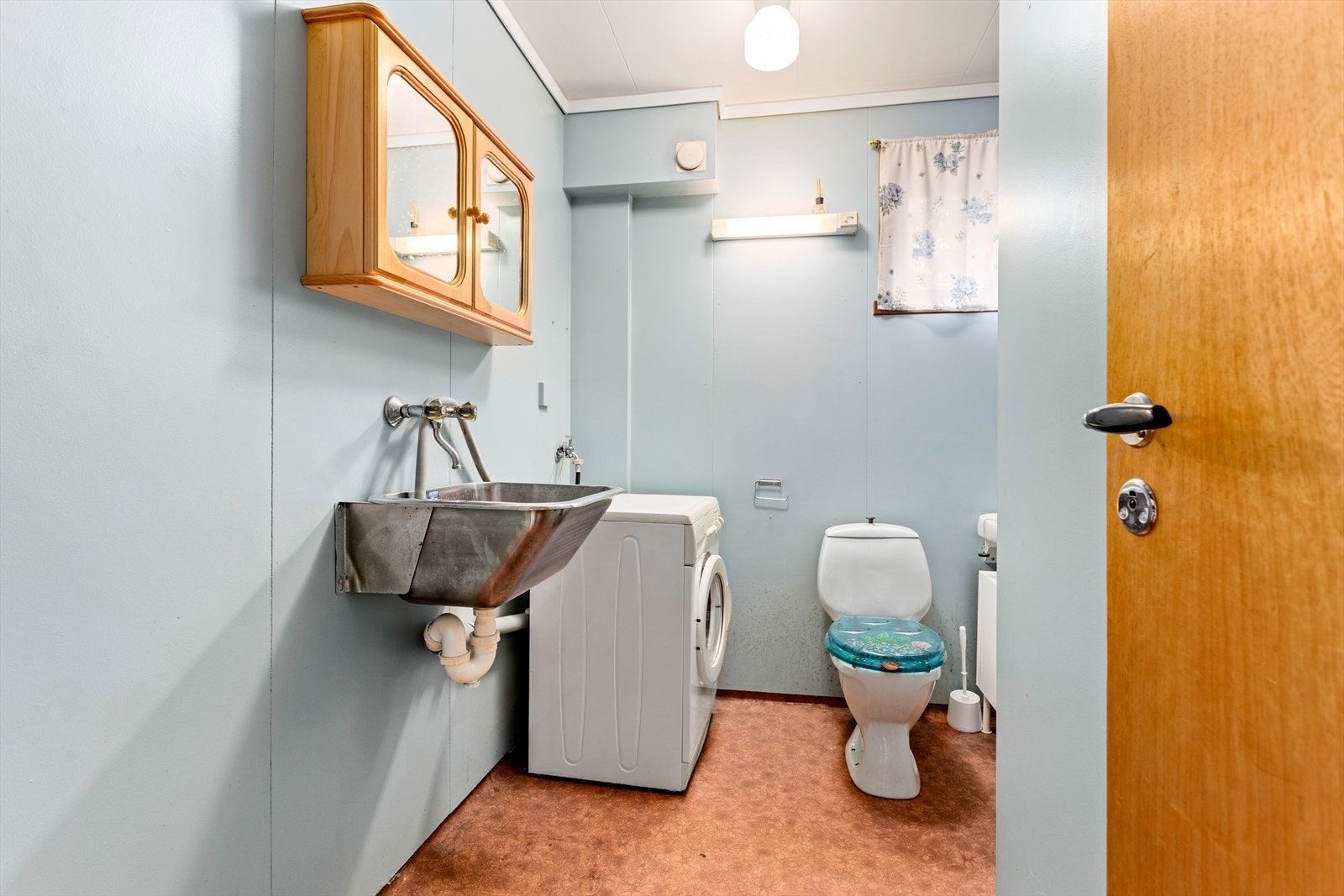 Badet inneheld toalett, servant, opplegg for vaskemaskin og dusjkabinett. Galleribilde