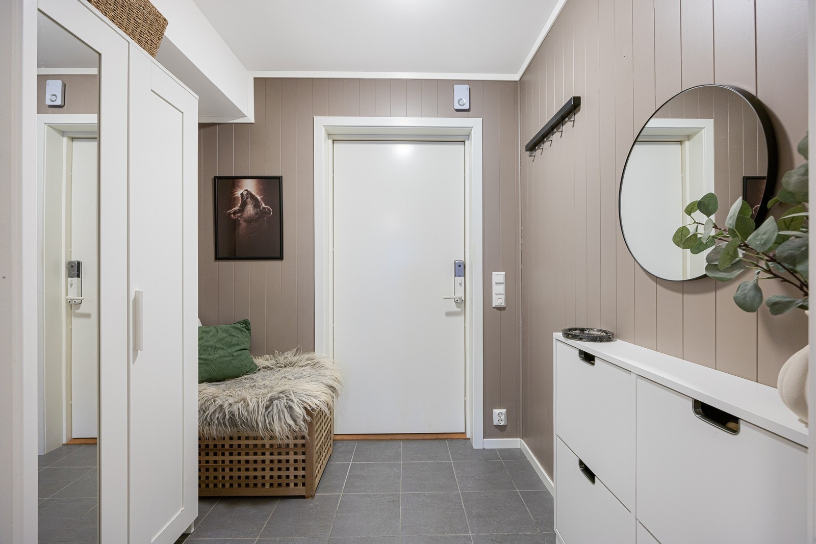 Entreen gir et godt førsteinntrykk, med varmekabler, grå gulvfliser og panelplater malt i en nydelig gråtone. Entreen har også et hvitt garderobeskap med dels speilfronter. Galleribilde