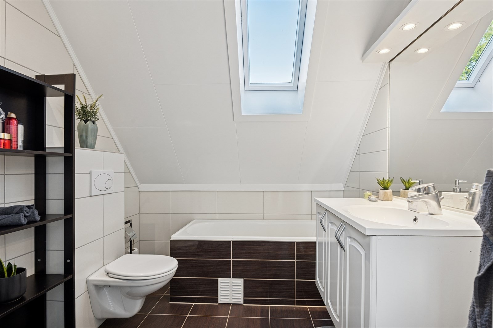 Badet er utstyrt med vegghengt toalett, badekar og dusjkabinett. Galleribilde