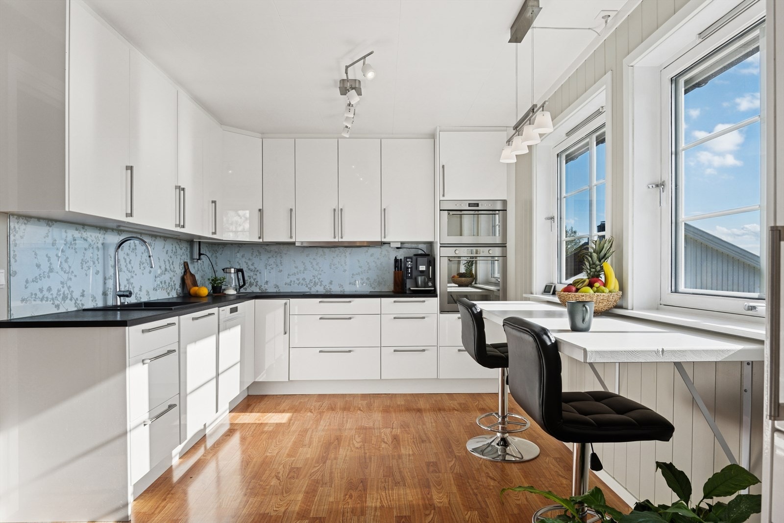 Lyst og innbydende kjøkken med integrerte hvitevarer. Galleribilde