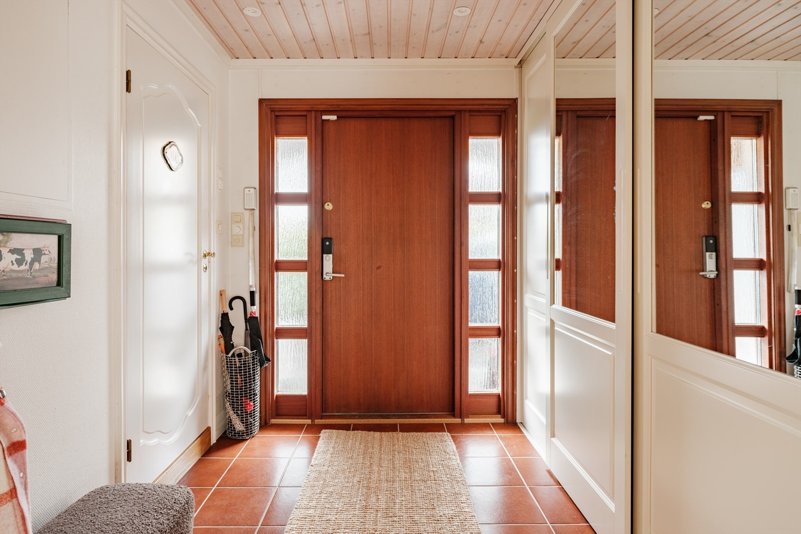 Romslig entré og gang med flislagt gulv og gulvvarme i entrésonen samt parkett i gang. Det er flere skyvedørsgarderober med speildører som gir gode oppbevaringsmuligheter. Galleribilde