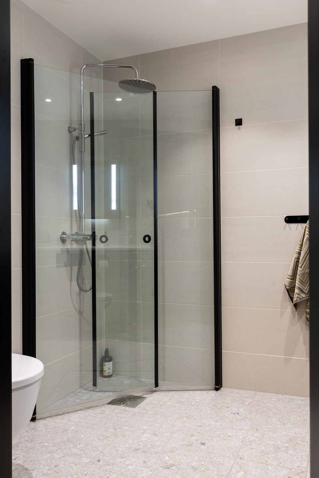 Dusjhjørne med svingbare glassdører og regnfallsdusj. Galleribilde