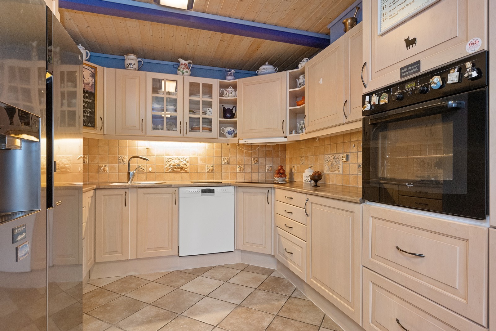 Kjøkkeninnredningen har profilerte fronter og vitrineskap Galleribilde