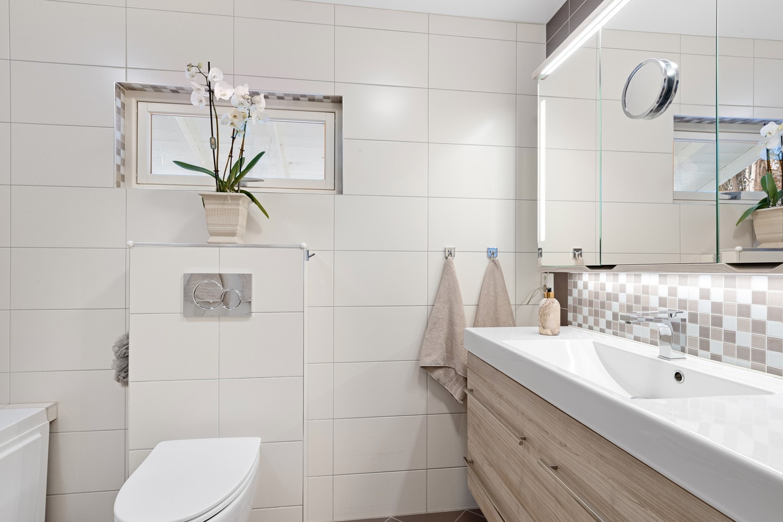 Baderomsinnredning med heldekkende servant og speilskap med integrert belysning Galleribilde