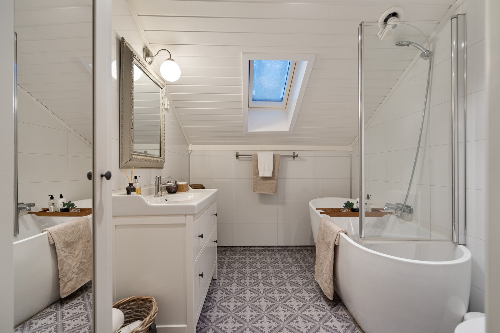 Badet i 2. etasje har baderomsplater på vegger, vinylbelegg på gulv og elektriske varmekabler. Rommet er utstyrt med servant, toalett og badekar, og har mekanisk avtrekk. Galleribilde