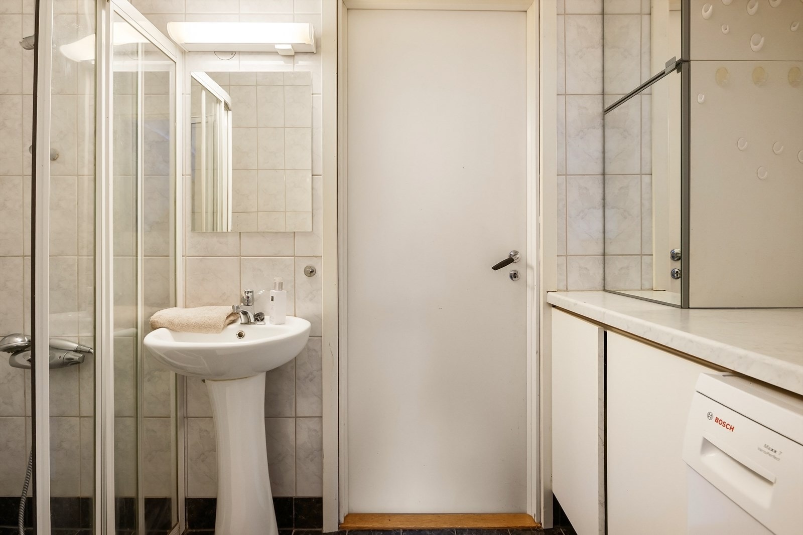 Praktisk vaskeromsløsning med vaskemaskin og god benkeplass. Galleribilde