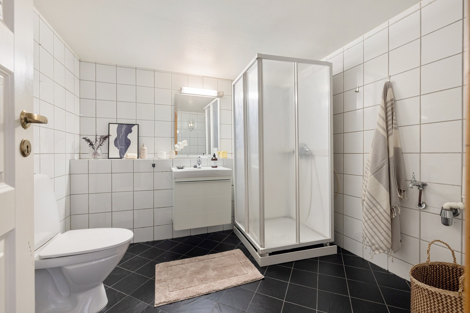 Badet har mørker 20x20cm fliser på gulv og Hvite 20x20cm fliser på vegger. Galleribilde