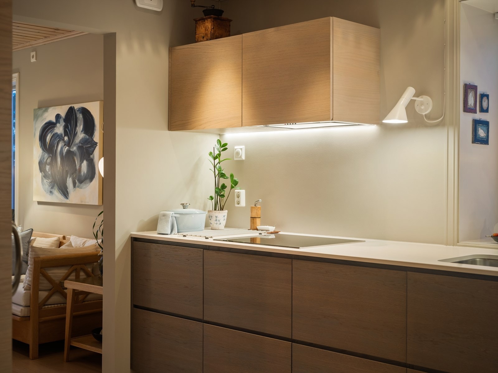 Kjøkkenet består av over-/underskap, komposit benkeplate, kjøleskap, oppvaskmaskin, helstøpt servant med kum, innfelt ovn og platetopp med ventilator over. Galleribilde