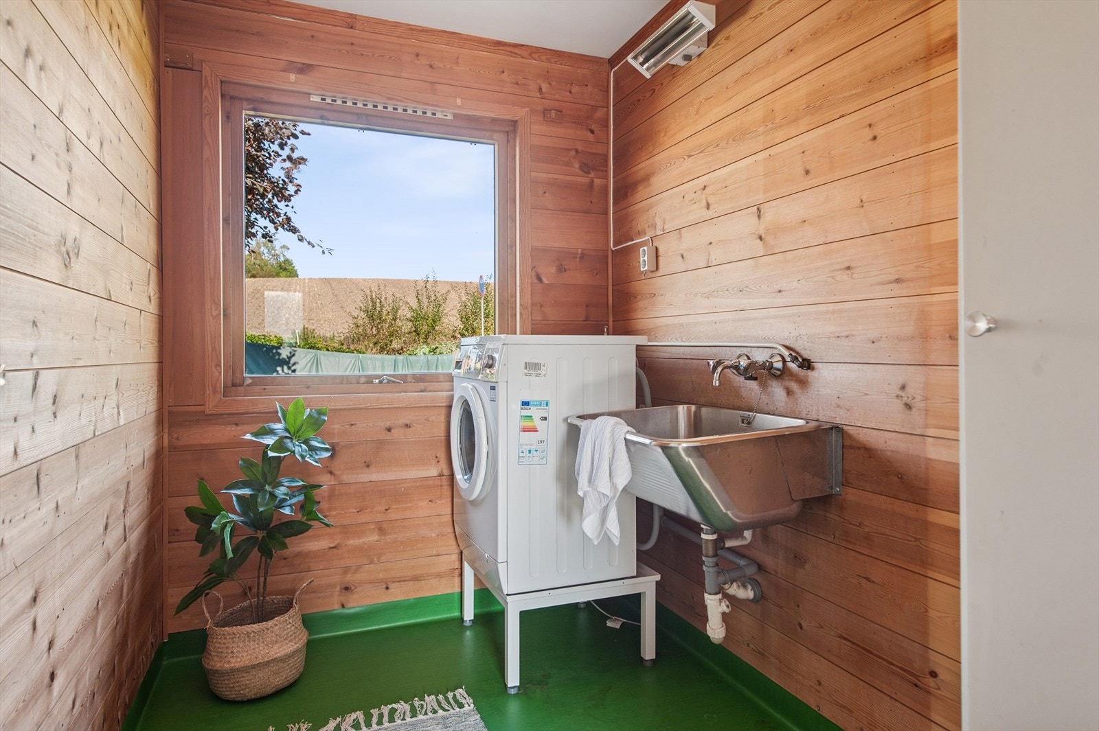 Vaskerommet i 1. etasje er fra byggeåret 1977. Gulvet er belagt med belegg og varmes opp av en elektrisk stråleovn. Utstyrt med vegghengt utslags kum. Galleribilde