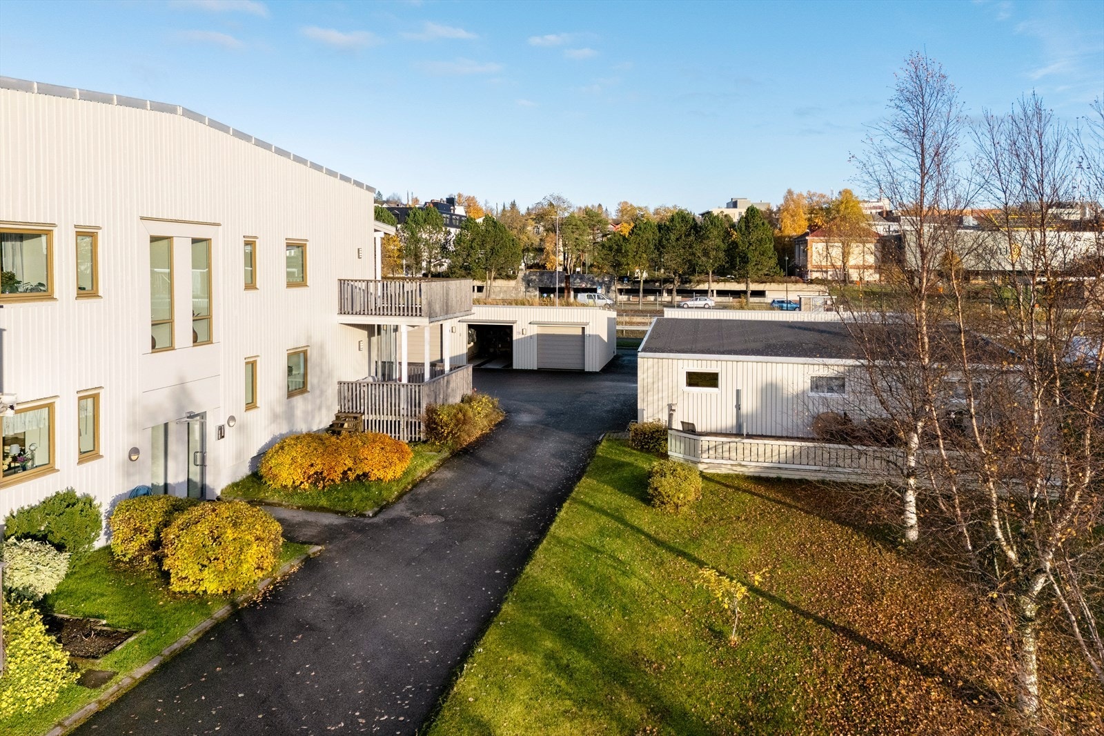 Stelte uteområder med plen, diverse beplantning og asfalterte felles veier. Galleribilde