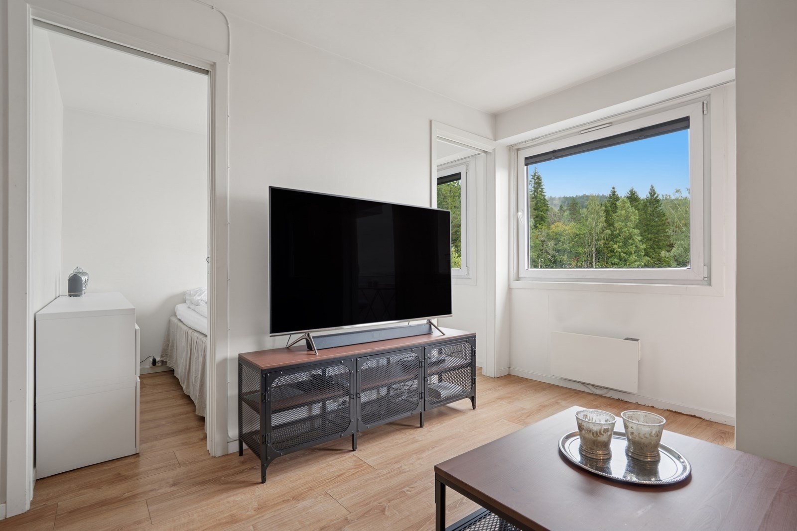 Fra stuen har du tilkomst til et lyst og pent soverom med vindu som gir både naturlig lys og utsikt. Galleribilde