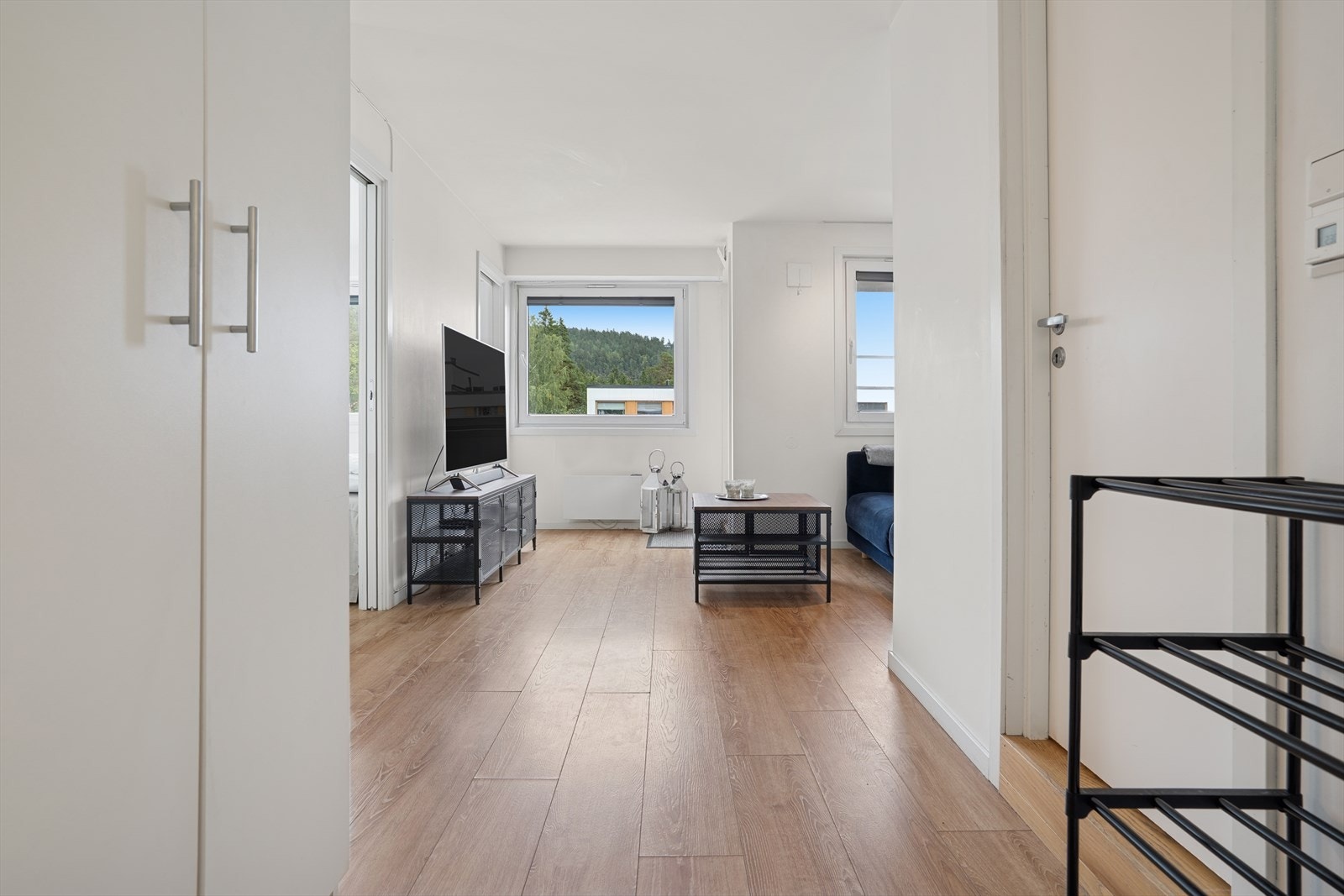 Fra det felles inngangspartiet tar heisen deg komfortabelt opp til leilighetsplanet, hvor en lys entré ønsker deg velkommen. Her er det god plass til å henge fra seg yttertøy og oppbevare sko i et praktisk dobbelt garderobeskap. Galleribilde