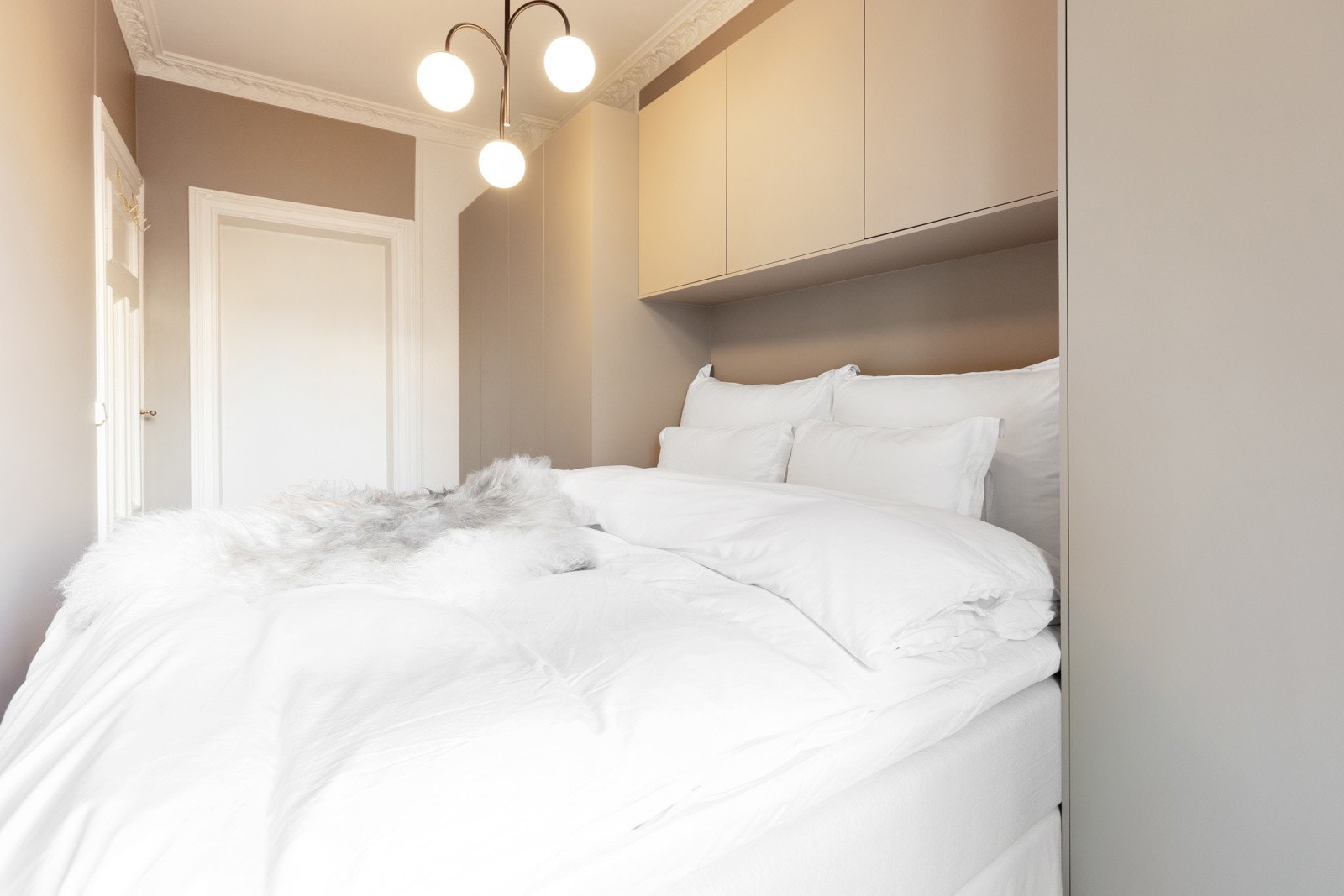 Plassbygd garderobeløsning rundt seng sikrer optimal plassutnyttelse. Galleribilde