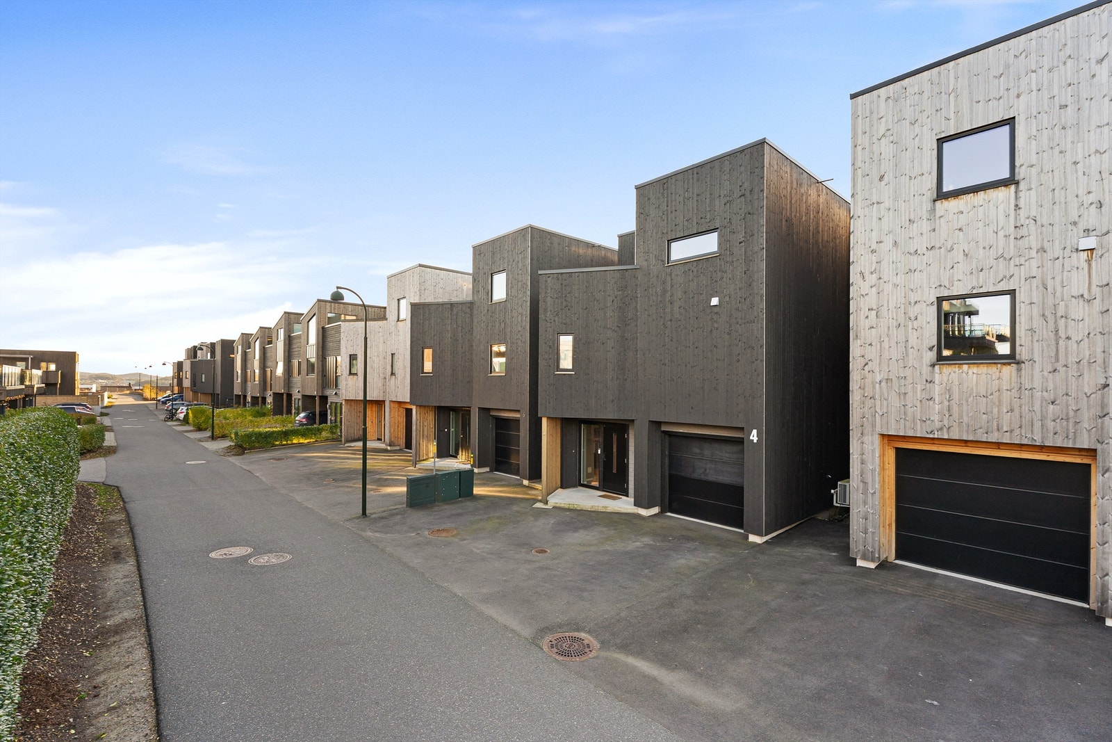 Uteområdet på fremsiden er asfaltert, og det er god plass til biler. Det er også El-bil lader i garasjen. Galleribilde