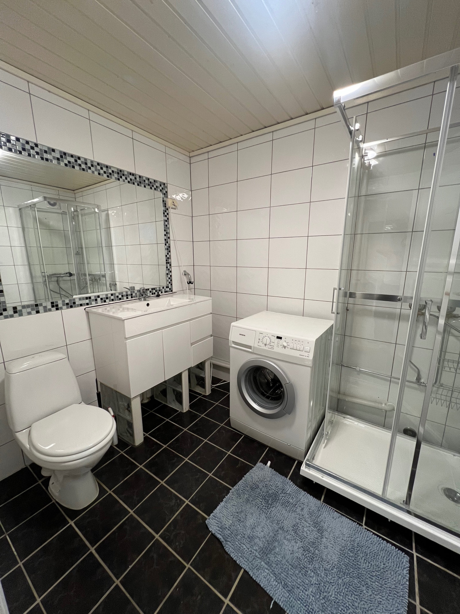 Baderommet med vaskemaskin og nytt dusjkabinett. Galleribilde