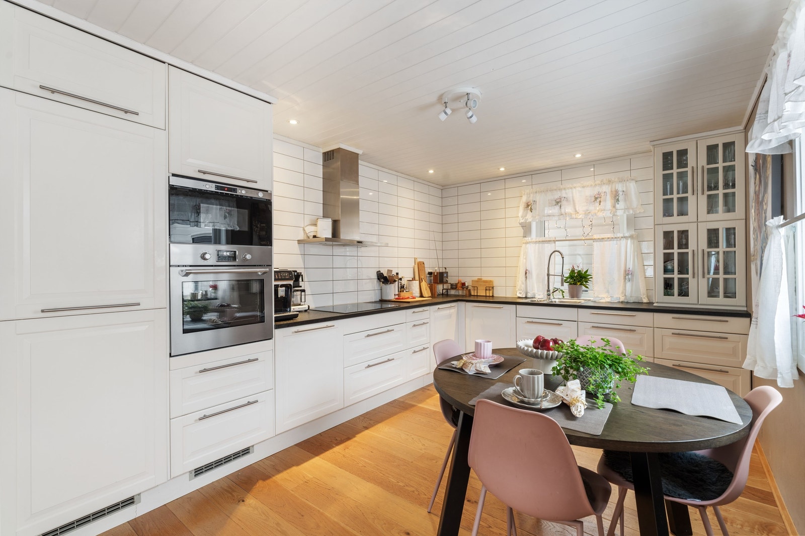 Kjøkkeninnredning fra 2012 med glatte fronter, laminat benkeplate og integrerte hvitevarer som platetopp, stekeovn, kjøleskap og oppvaskmaskin. Galleribilde