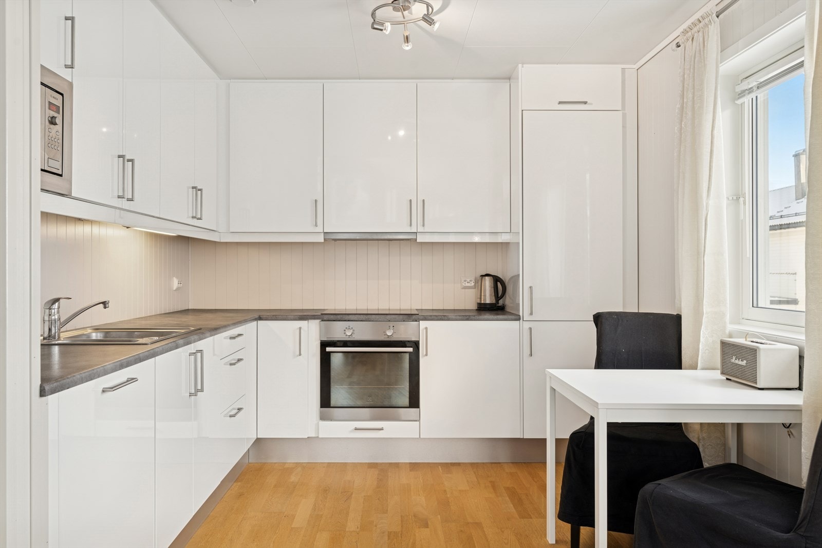 Kjøkkenet har en tidløs utførelse med lyse fronter, samt både over- og underskap. Galleribilde