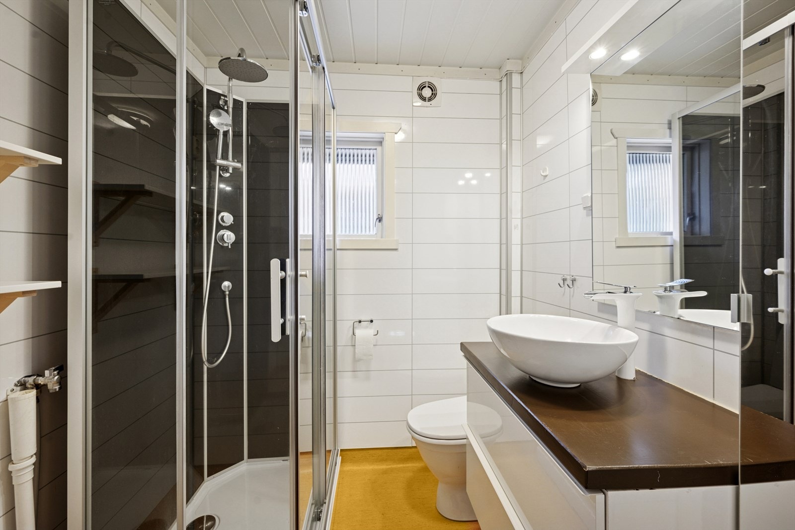 Bad/vaskerom - Veggene har baderomsplater. Gulvet har vinylbelegg. Rommet har servant, toalett, dusjkabinett og opplegg for vaskemaskin. Mekanisk avtrekk. Galleribilde