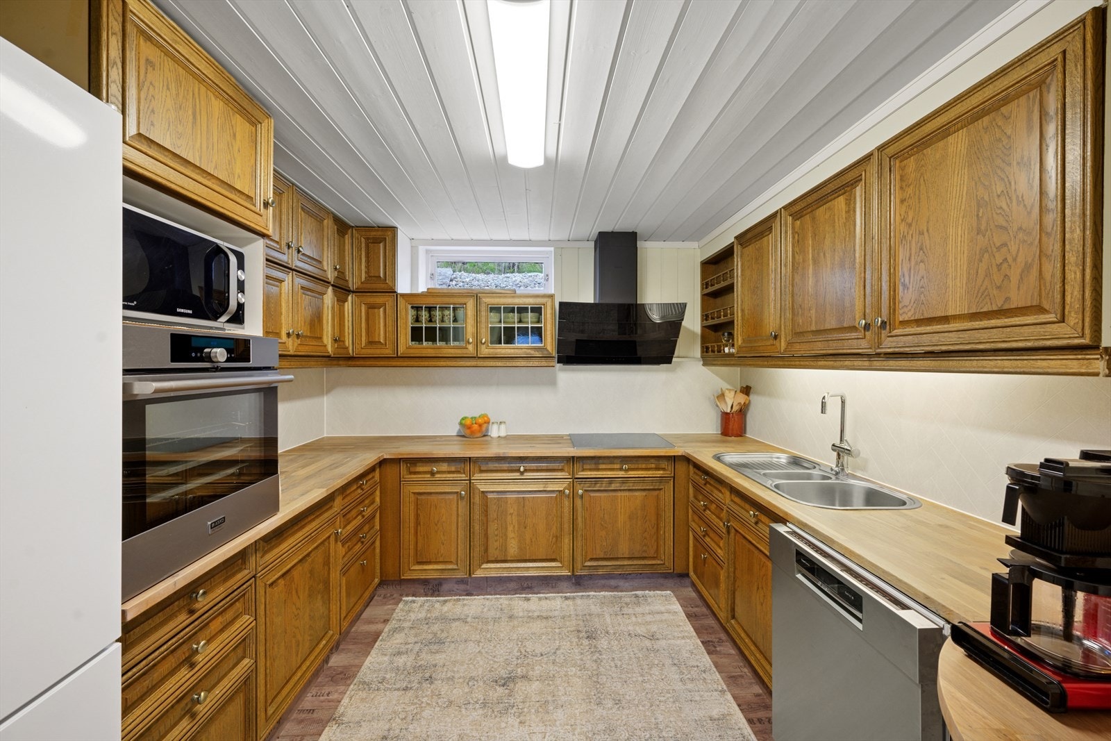 Kjøkkenventilator med avtrekk ut. God skap- og benkeplass og innredning slik at matlagingen forenes med sos Galleribilde