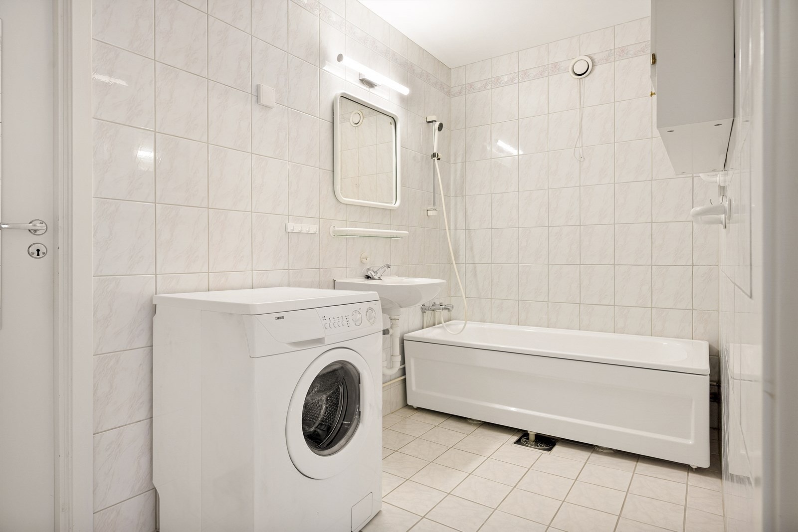 Badet er helfliset og utstyrt med badekar og opplegg for vaskemaskin. Galleribilde