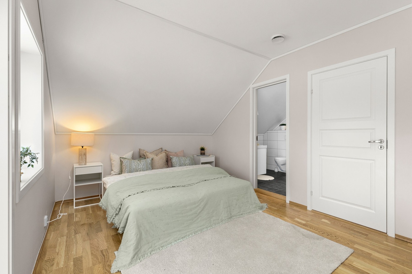 Romslig loftstue som brukes som soverom på 12 kvm med eget bad. Galleribilde