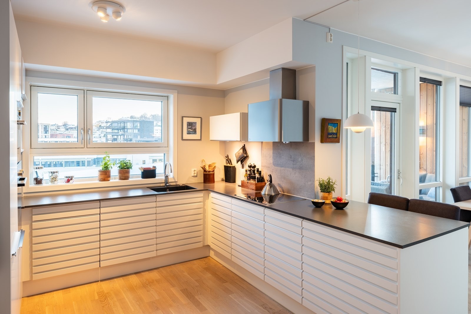 Kjøkkenbenken er forlenget med en praktisk barløsning - perfekt til matlaging eller en rask frokost før jobb. Galleribilde