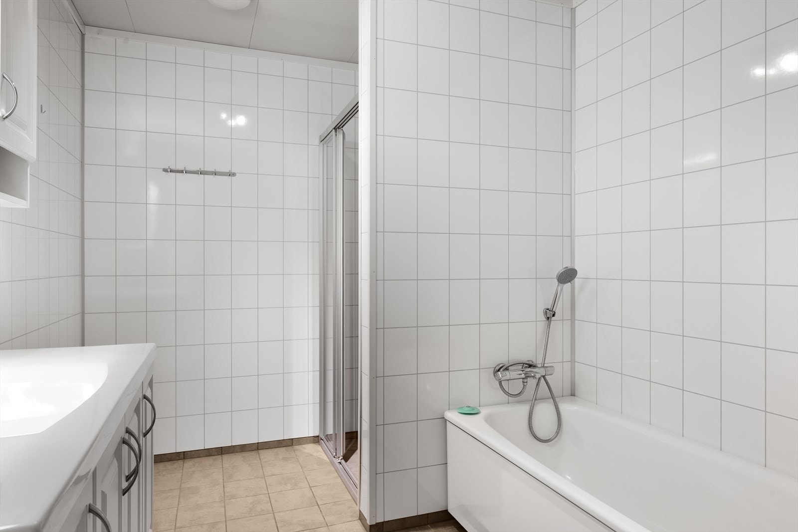 Badet har lyse våtromsplater på vegg og flislagt gulv. Galleribilde