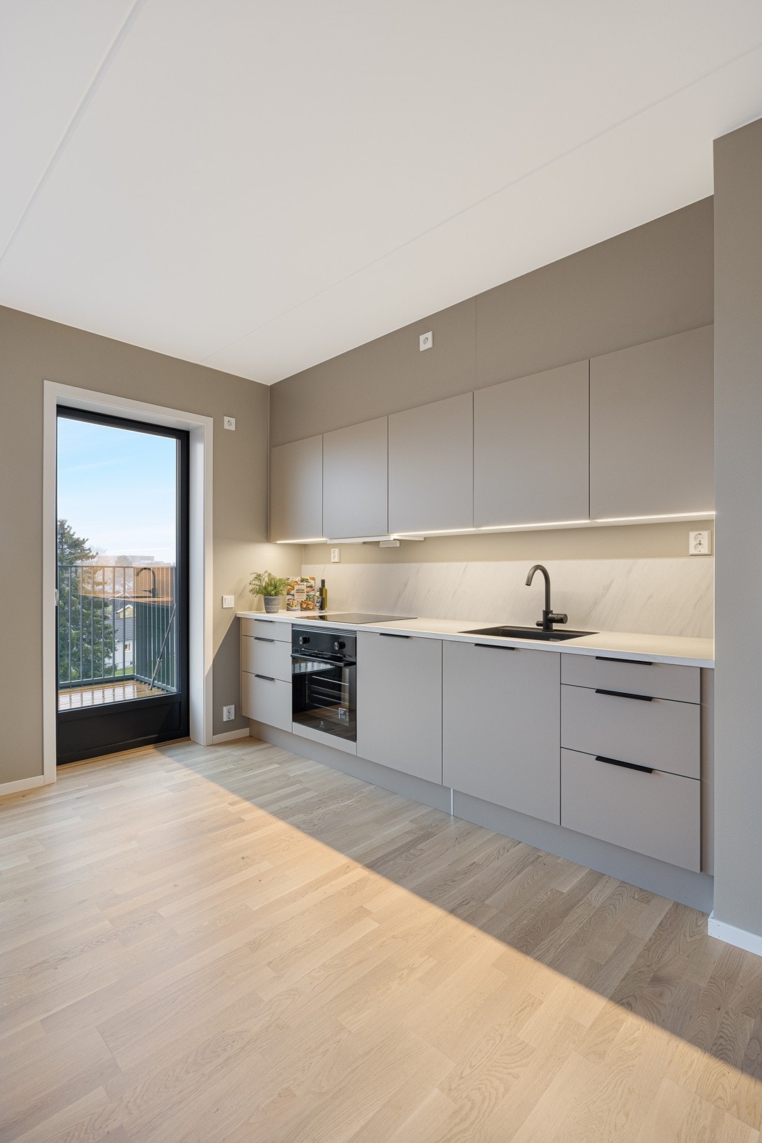 Med integrerte hvitevarer og sort armatur er stilen helhetlig. Galleribilde