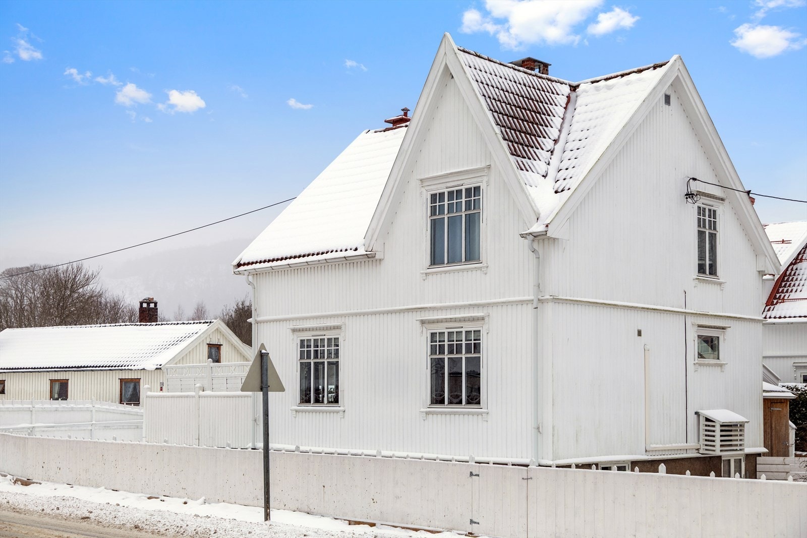 Sjarmerende enebolig i et hyggelig nabolag med tradisjonell norsk byggestil, med hvitmalte vegger og røde/oransje tak. Galleribilde