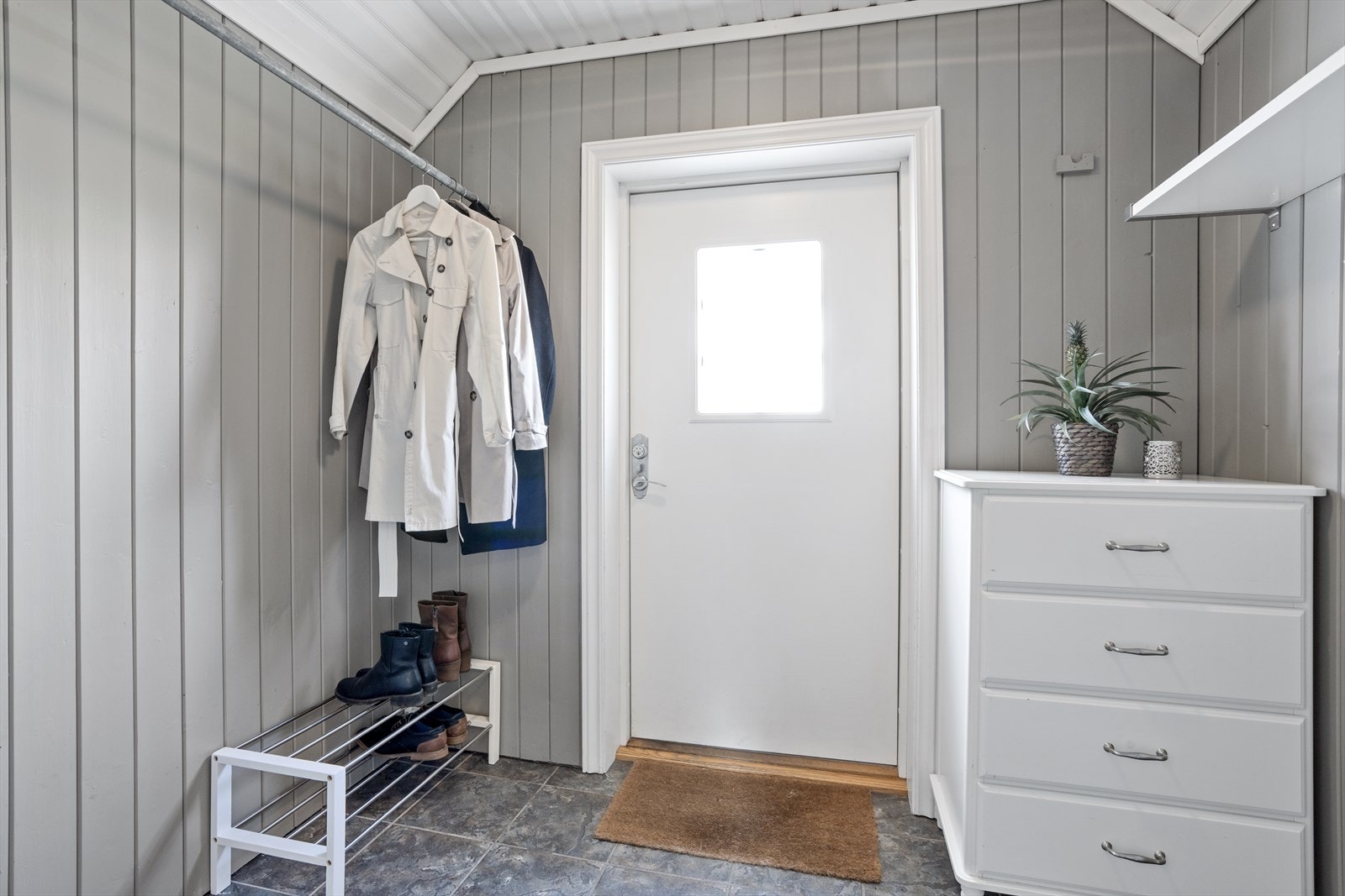 Vindfanget har heng til jakker, hattehylle og kommode. Galleribilde