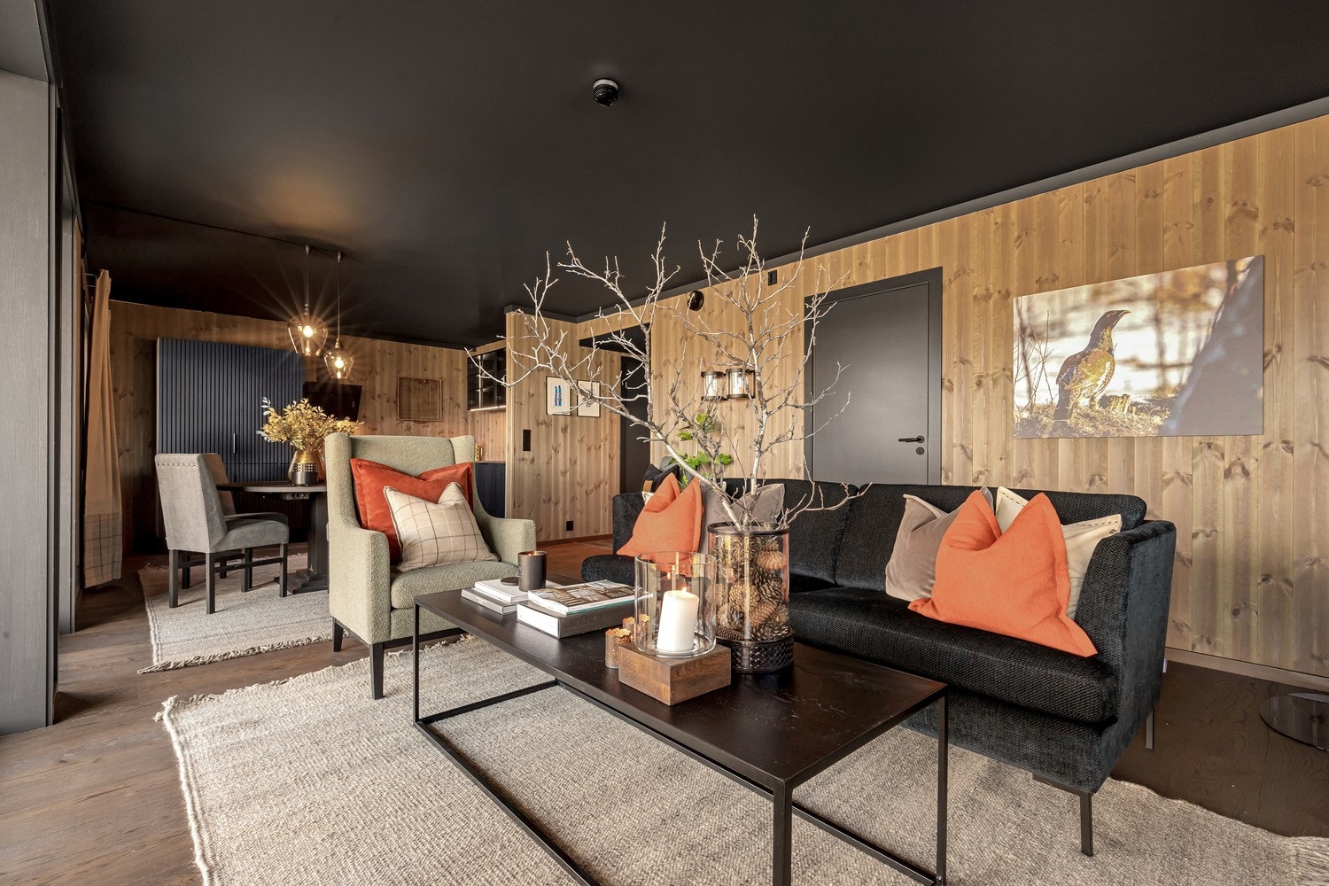 Stuen preges av lekker trepanel på vegg, mørke, stilsikre 1-stavs eikeparkett og en moderne fargepalett Galleribilde