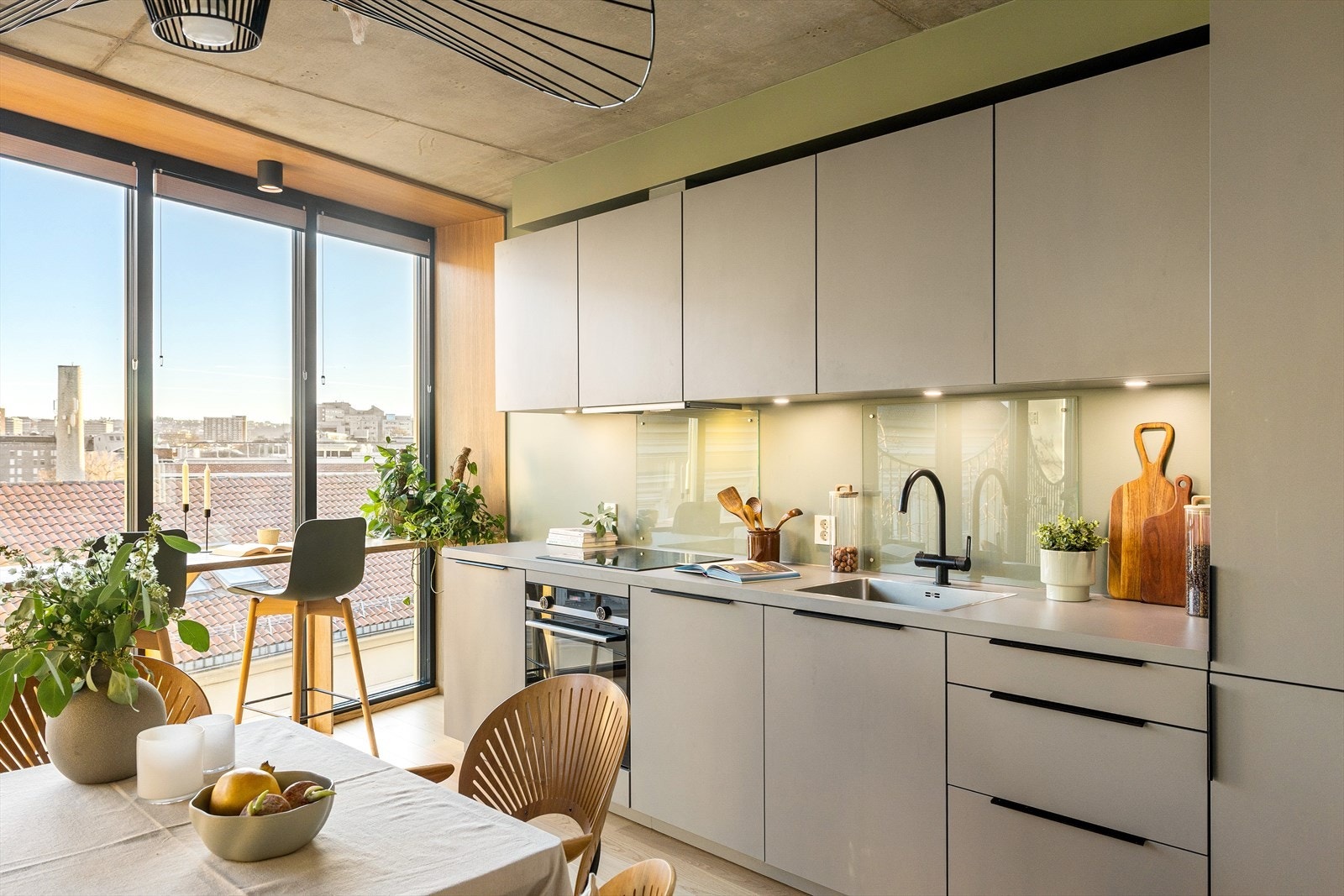 Tidsriktig innredning fra 2021 med glatte fronter og benkeplate i laminat (2025). Det er sprutplate av glass over oppvaskkum og platetopp. Galleribilde