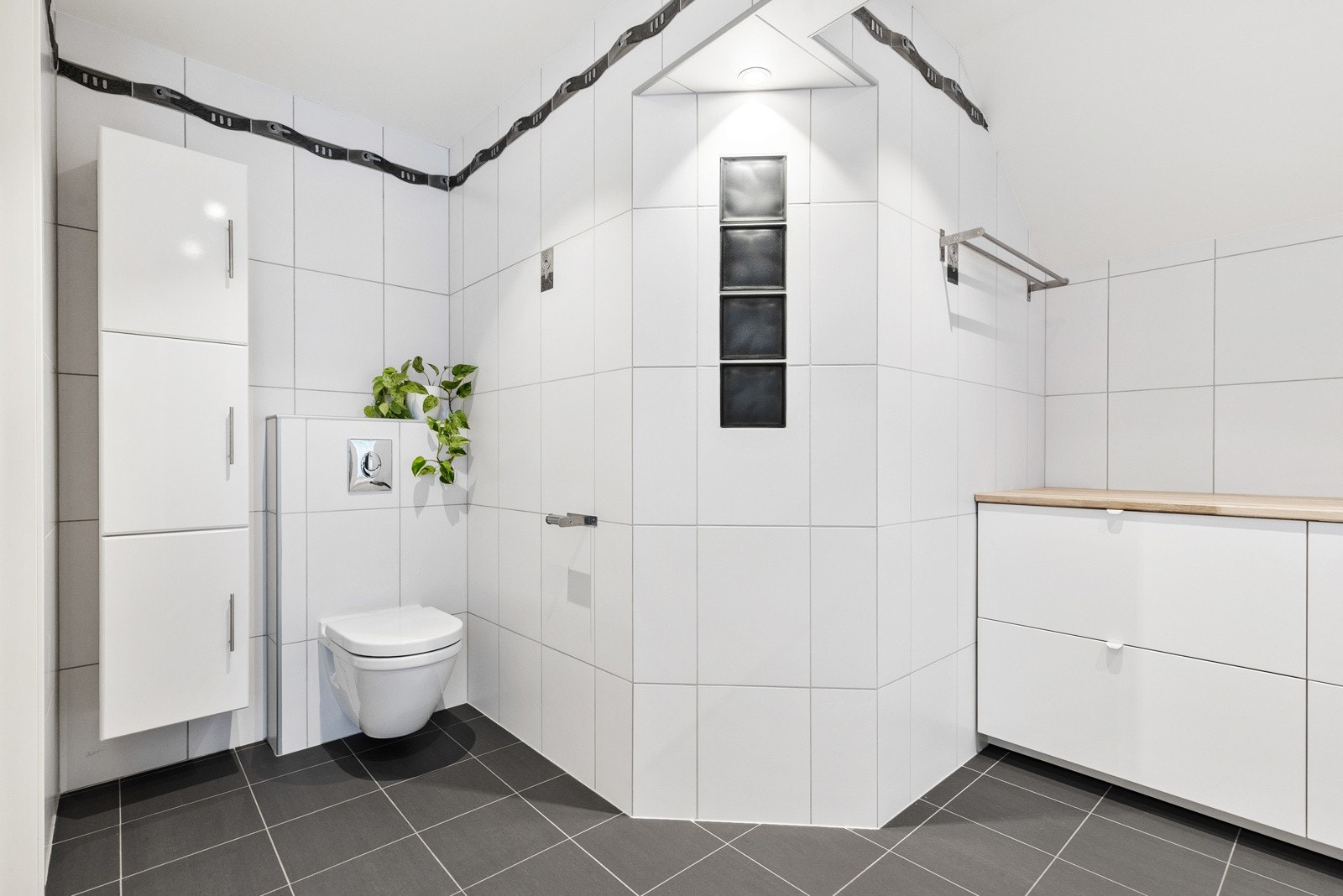 Badet har helfliset overflater og downlightsbelysning. Galleribilde