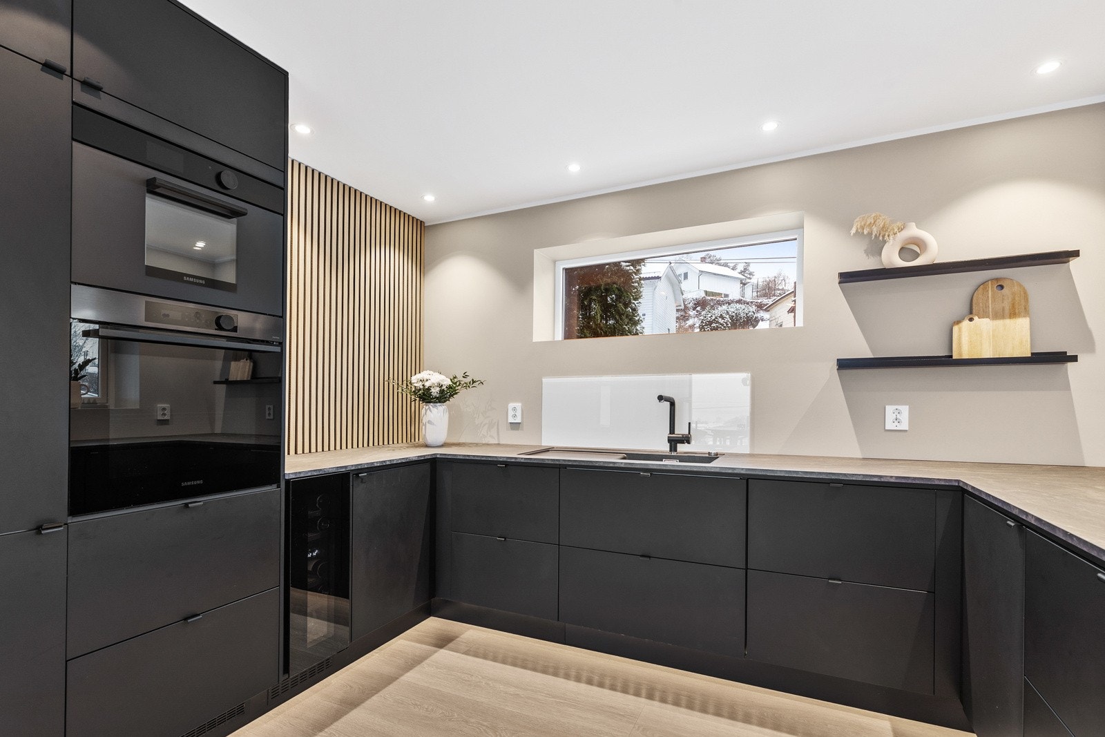 Det er montert backsplash ved vask og platetopp. Galleribilde