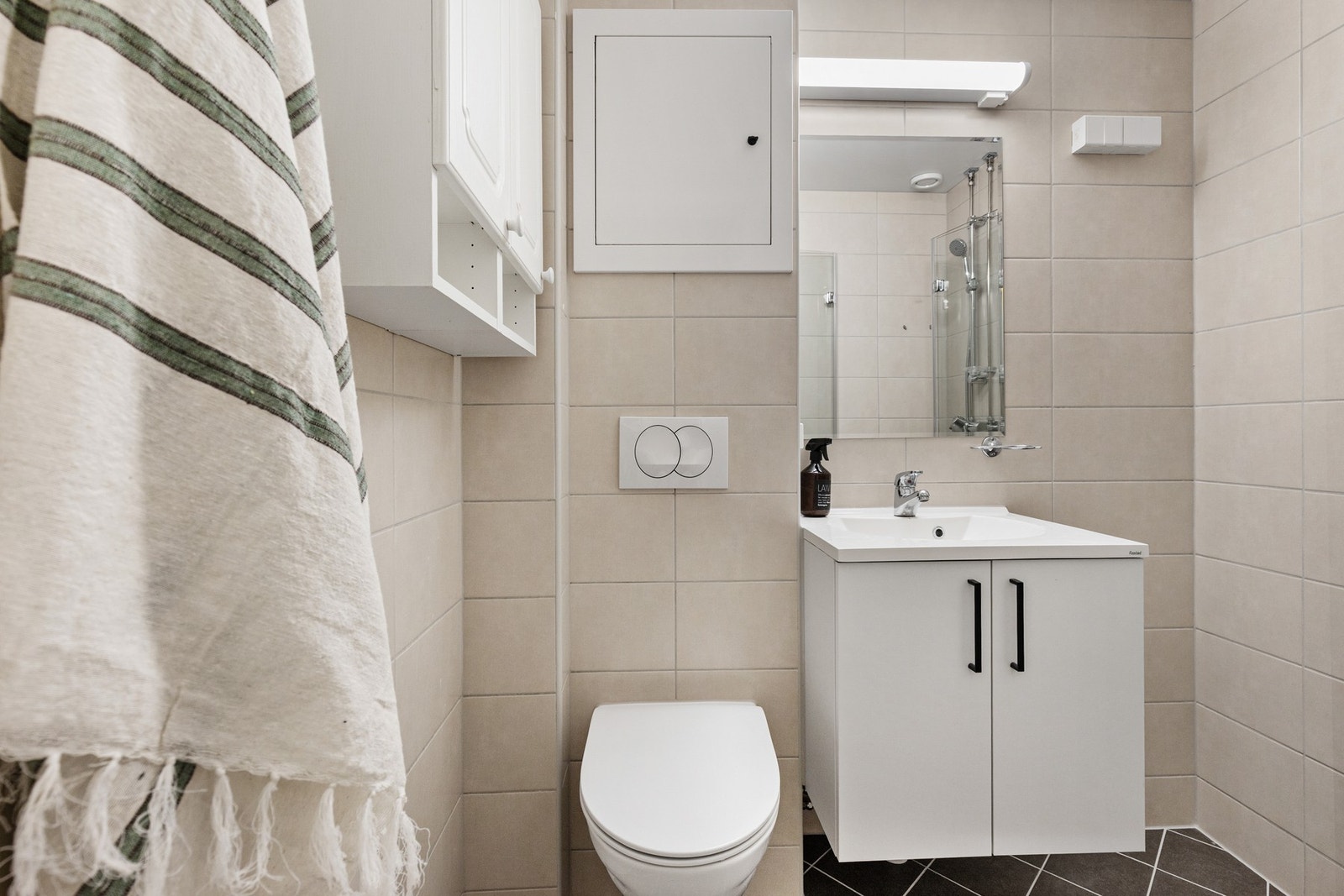 Rommet er innredet med fliser på både vegger og gulv, samt slett himling som gir et rent og pent uttrykk. Galleribilde