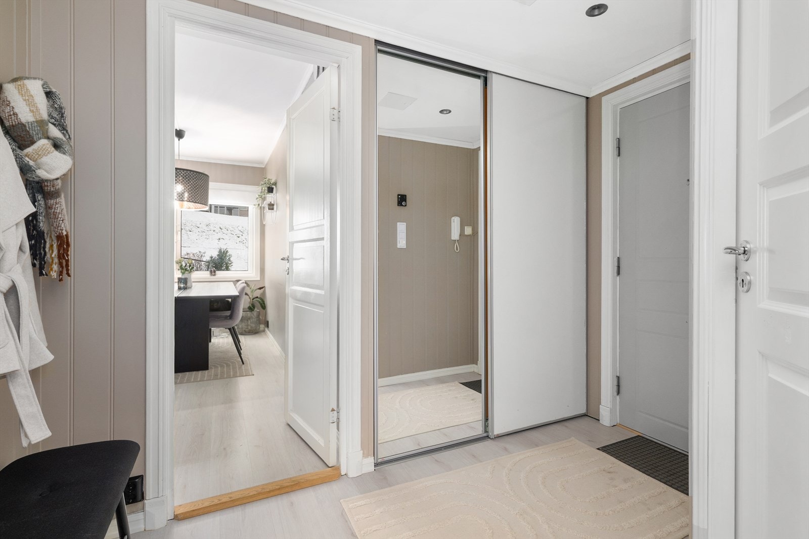 Fin og romslig entré med plass til oppbevaringsmøblement for sko- og yttertøy. Det er laminat på gulv og malte panelplater på vegger, samt malt tak. Fra entré er åpent inn til stuen, samt dør til kjøkken og bad. Galleribilde