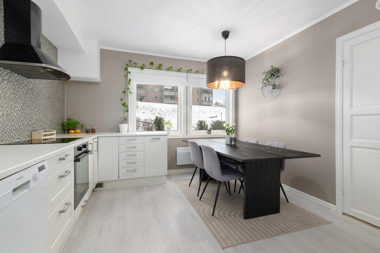 Pent kjøkken med god plass til spisegruppe og lys kjøkkeninnredning type Ikea fra ca. 2015. Galleribilde