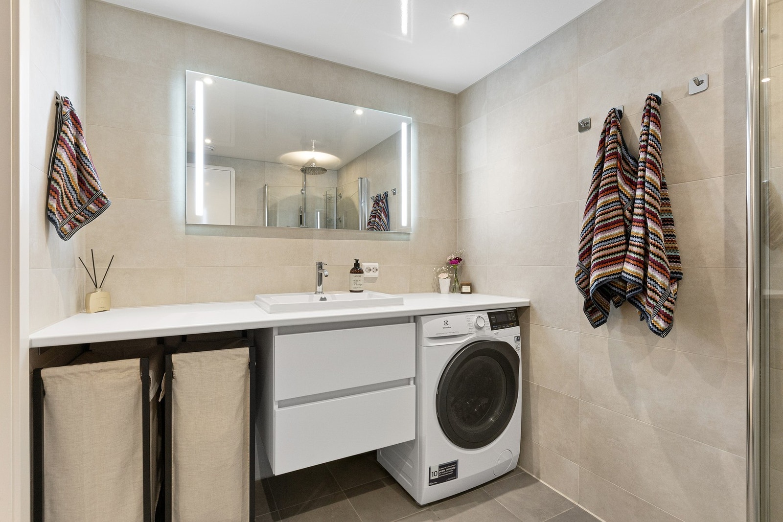 Badet har praktisk innredning og det er opplegg for vaskemaskin. Galleribilde