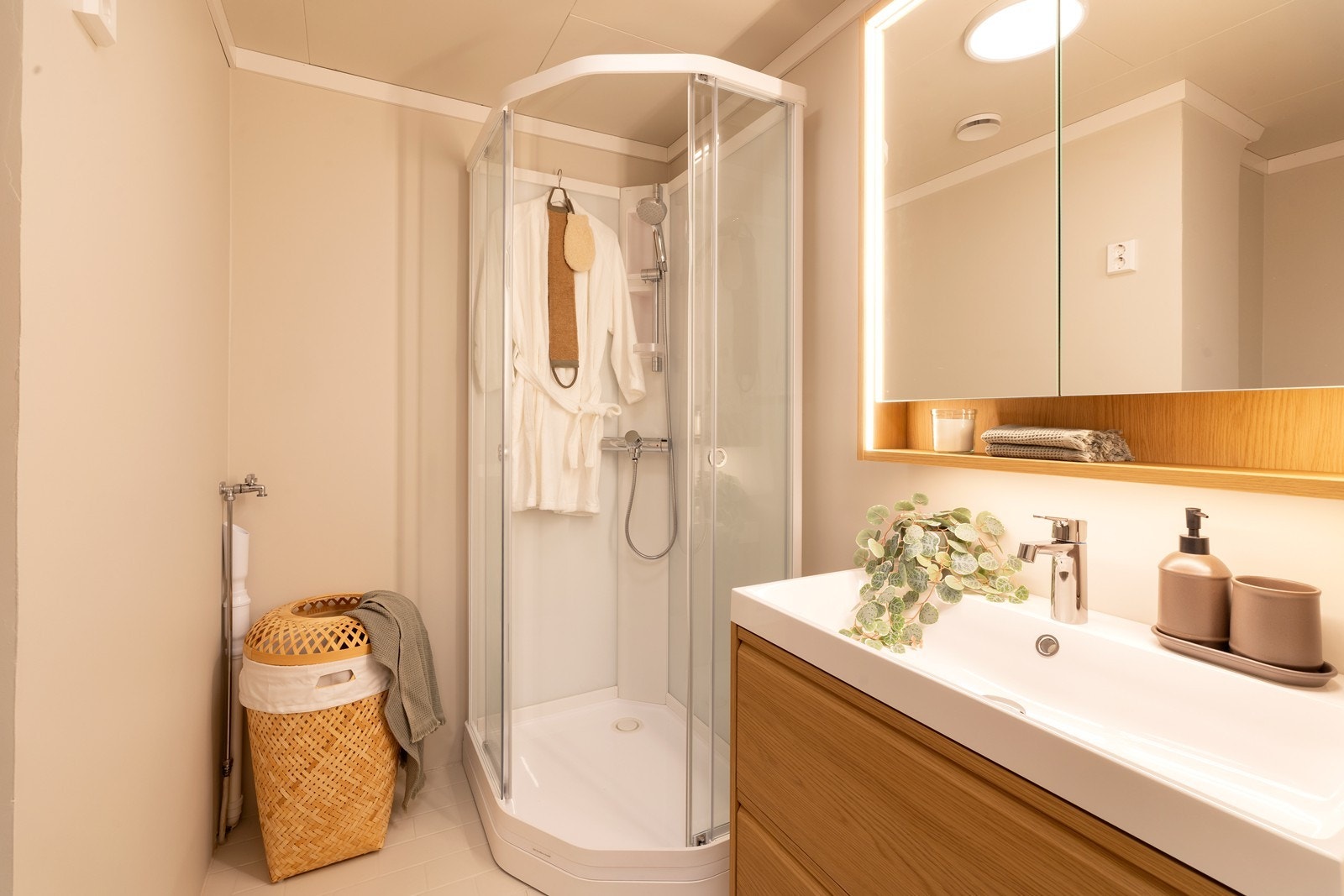 Baderommet inneholder toalett, dusjhjørne og servant med oppbevaring. Opplegg for vaskemaskin. Galleribilde