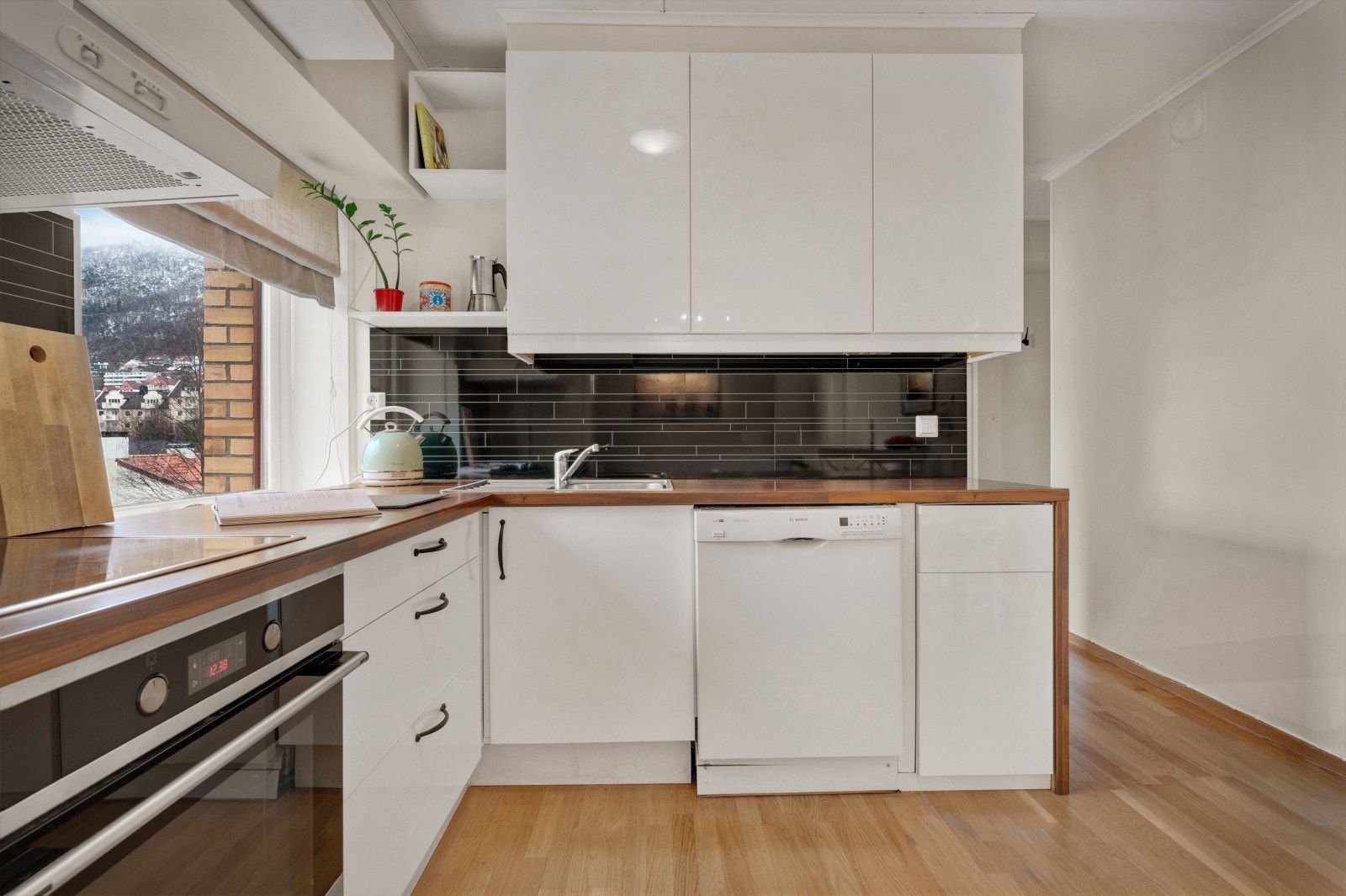 Kjøkkenet er tidløst innredet med hvite fronter og laminat benkeplate. Galleribilde