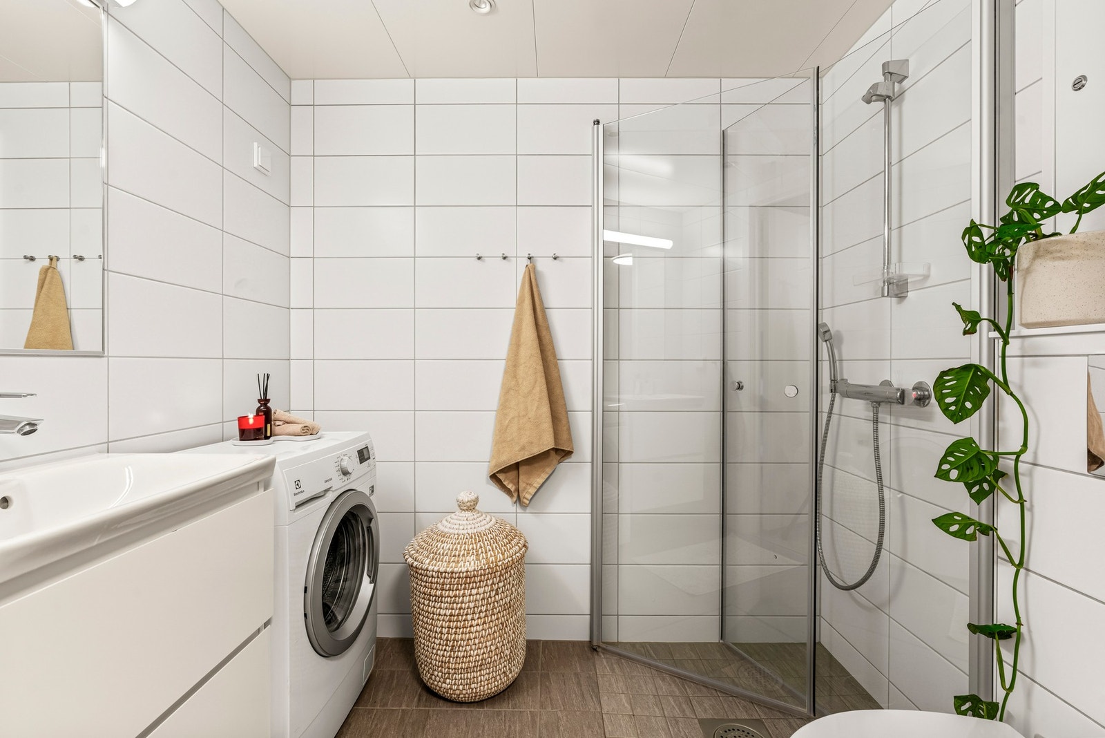 Moderne, flislagt bad med opplegg til vaskemaskin. Galleribilde