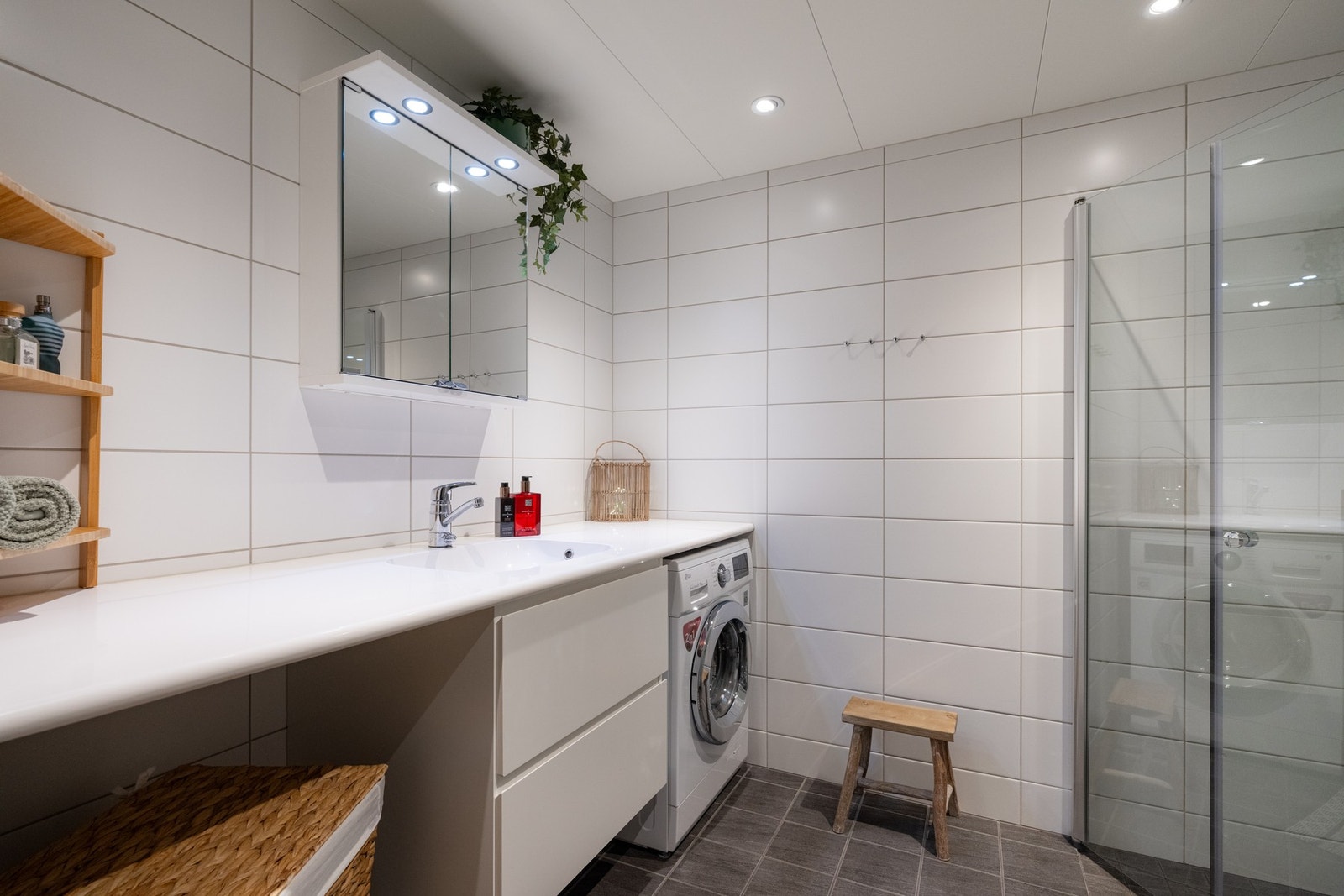 På badet er det baderomsinnredning med to skuffer med nedfelt servant, speilskap med belysning over, vegghengt toalett og dusj med innfellbare dusjvegger som frigjør plass på gulvet. Galleribilde