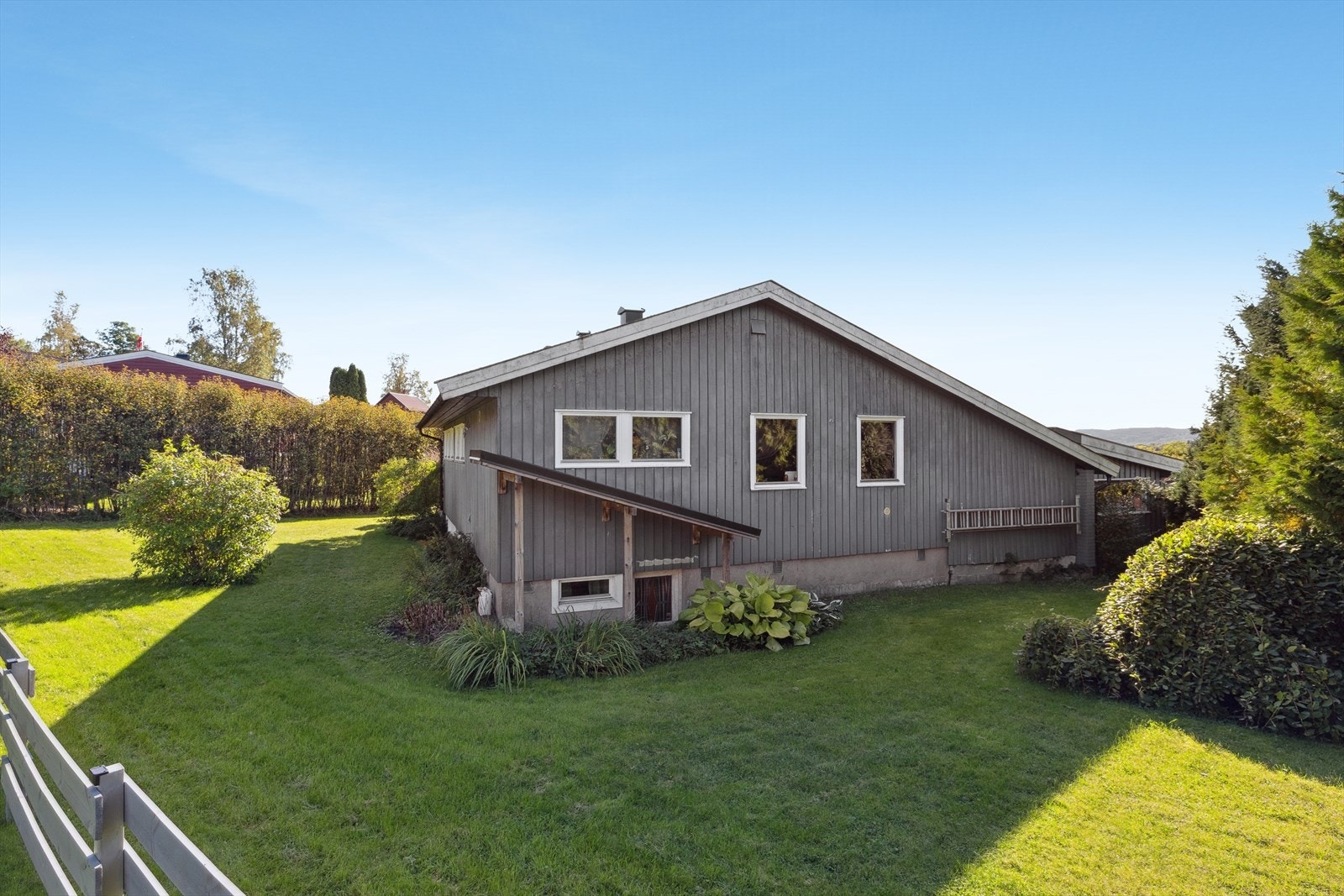 Det er stor gressplen rundt boligen. Galleribilde