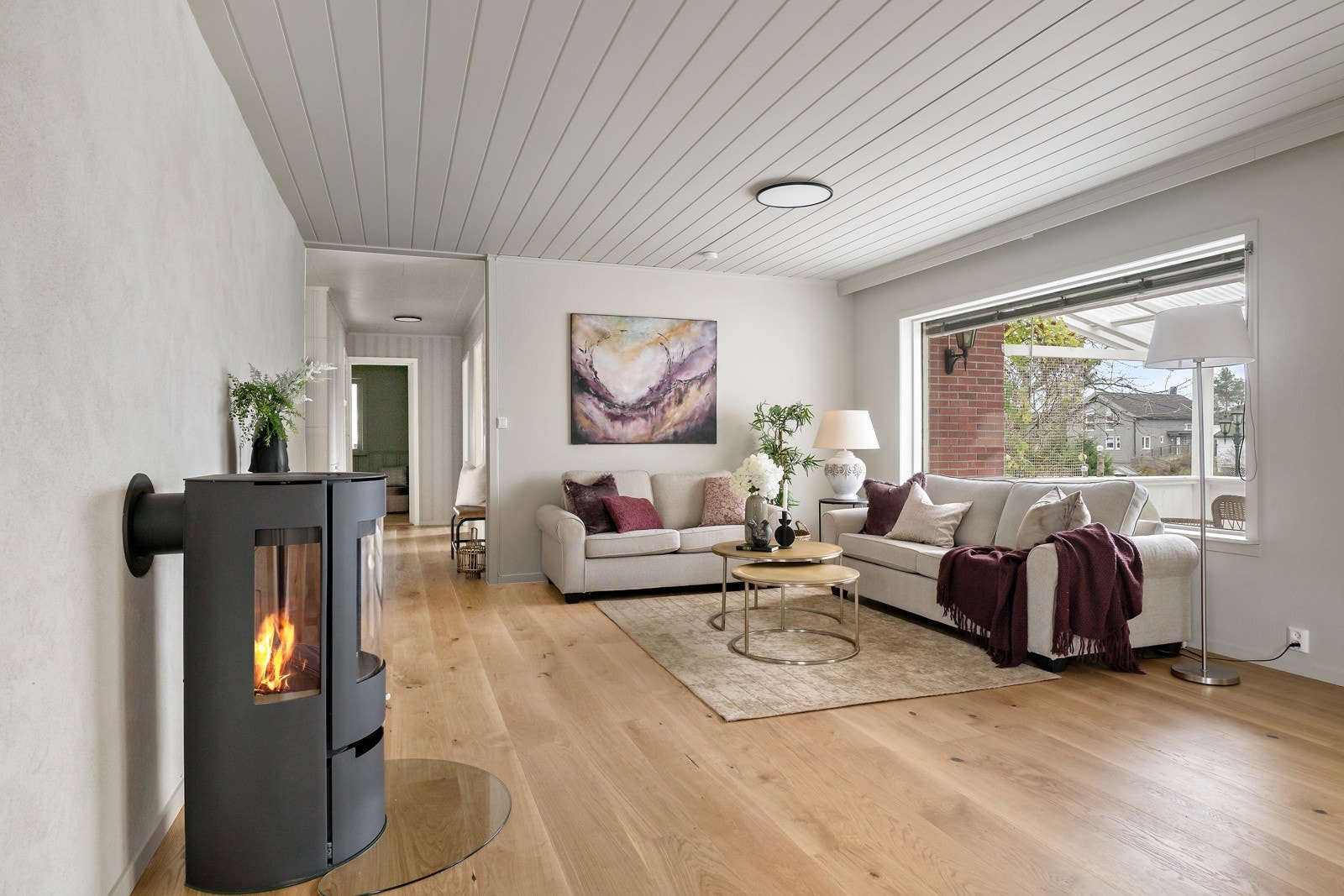 Boligen har et lyst og innbydende allrom med peisovn. Galleribilde