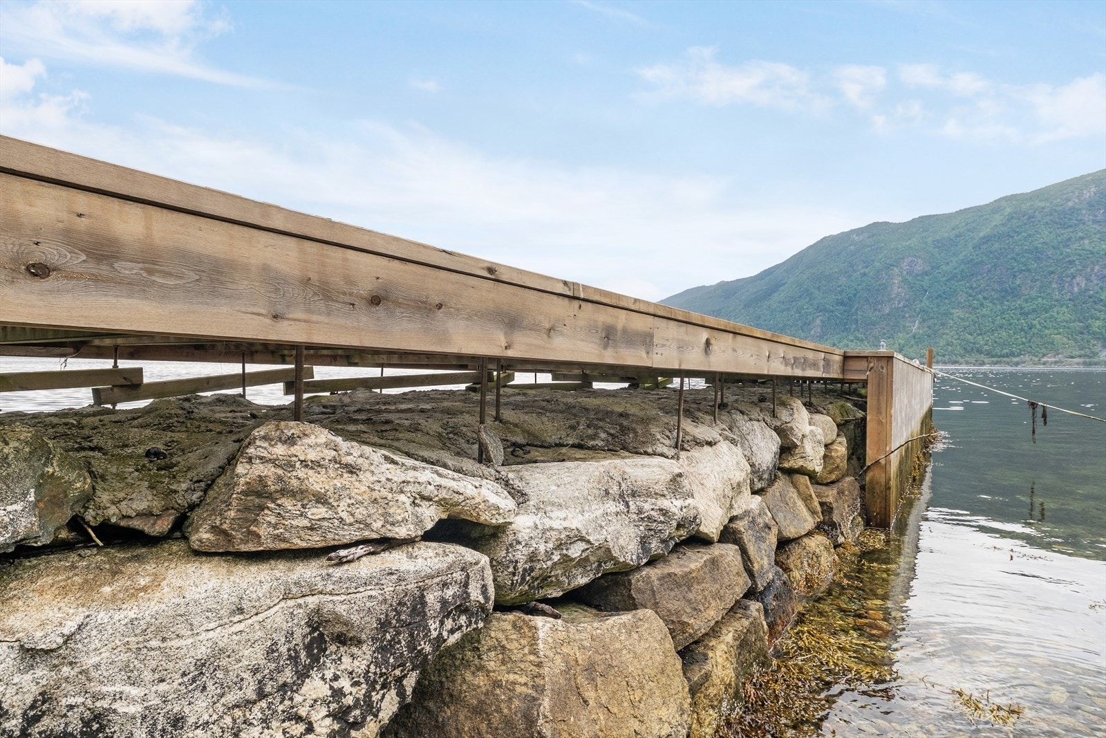 Brygga er bygd som steinmolo, dekka av betong for å hindre utgliding av stein. Tredekke, bjelkelag, og skjørt er utført i trykkimpregnert furu. Galleribilde