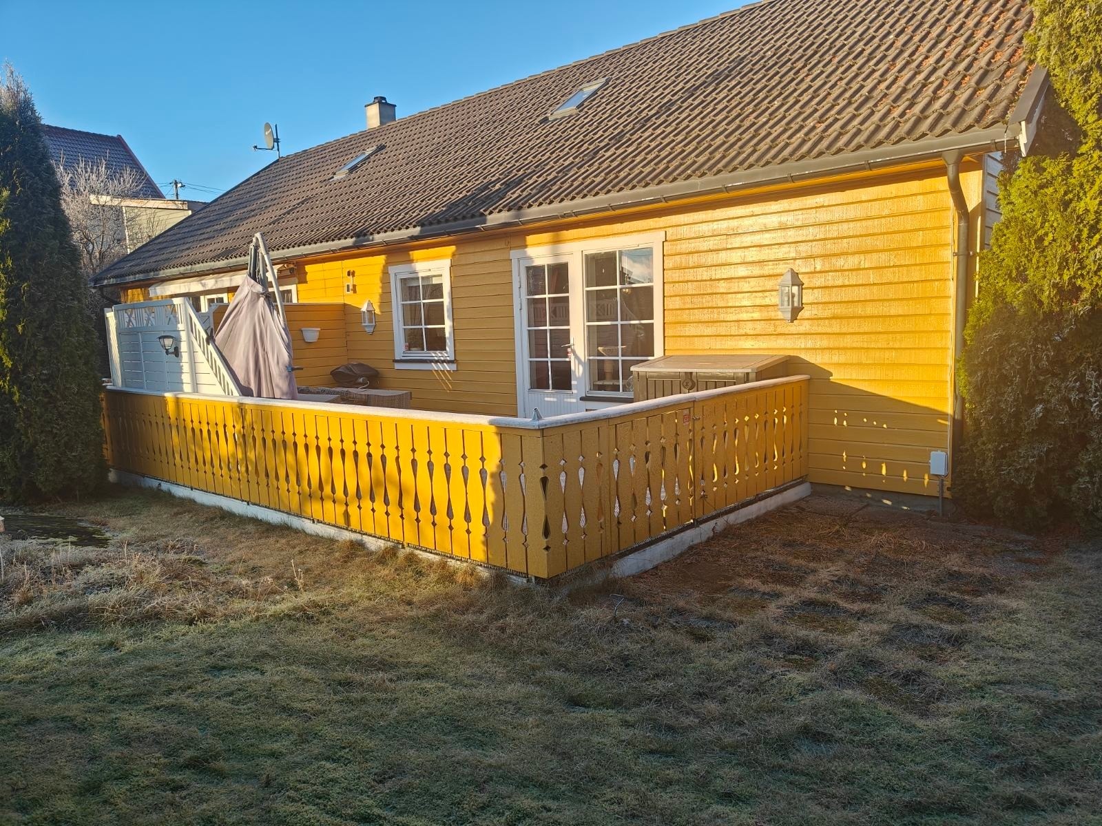 Det er en skjermet hage med gressplen og beplantning. Galleribilde