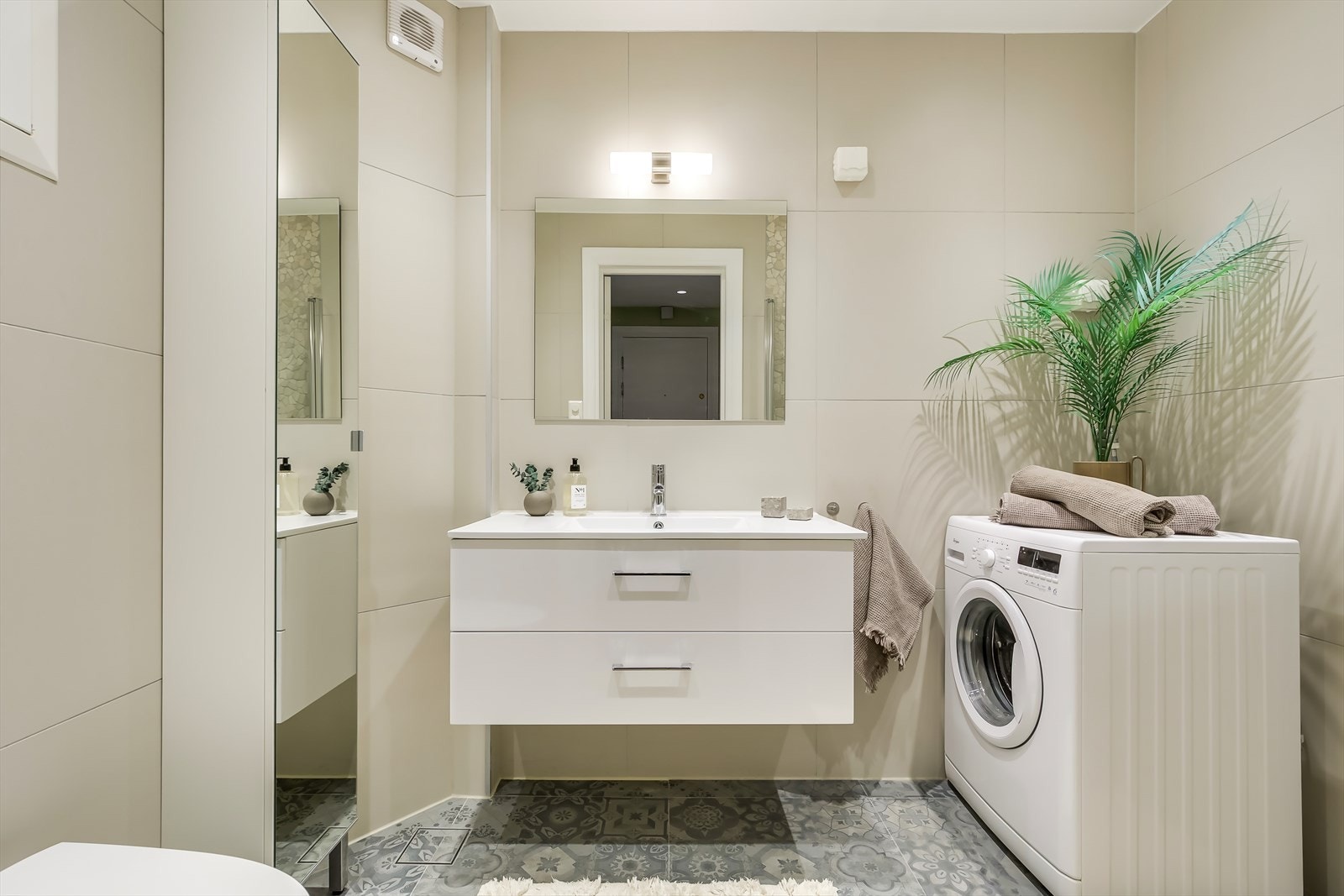 Innredningen består av vegghengt toalett, servant, speil og dusjhjørne med glassdører. Galleribilde