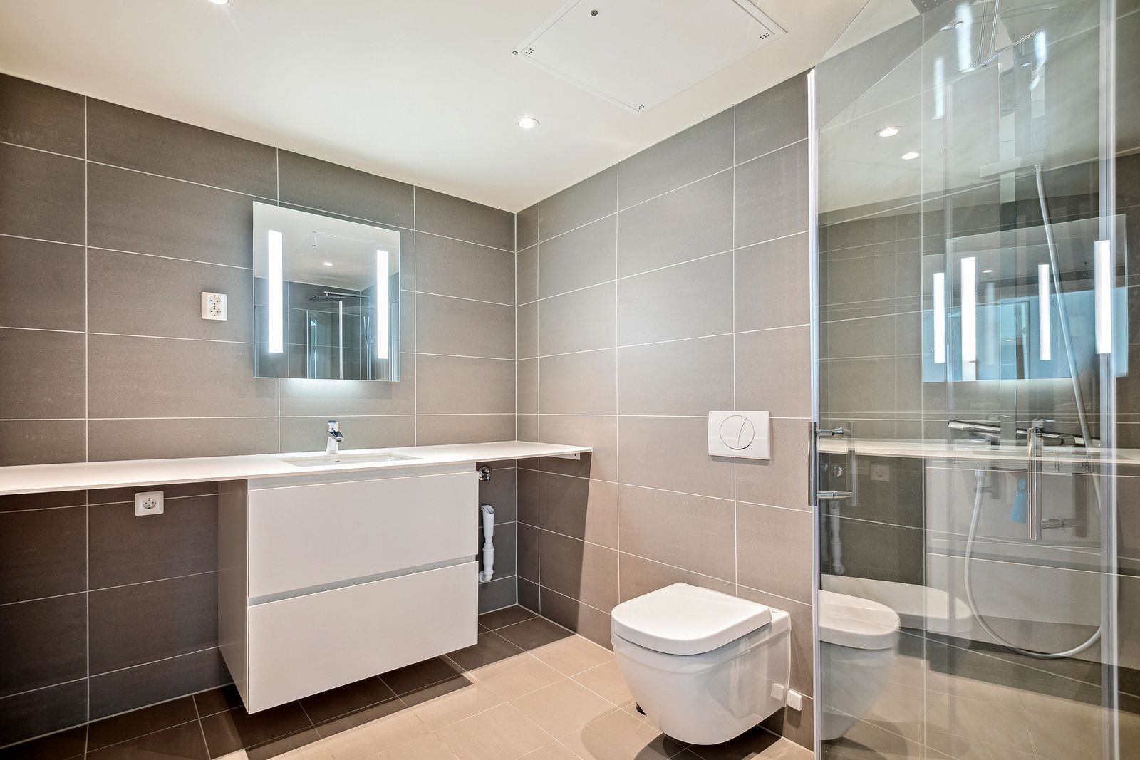 Lekkert flislagt bad med dusjhjørne, opplegg for vaskemaskin og varme i gulv. Galleribilde