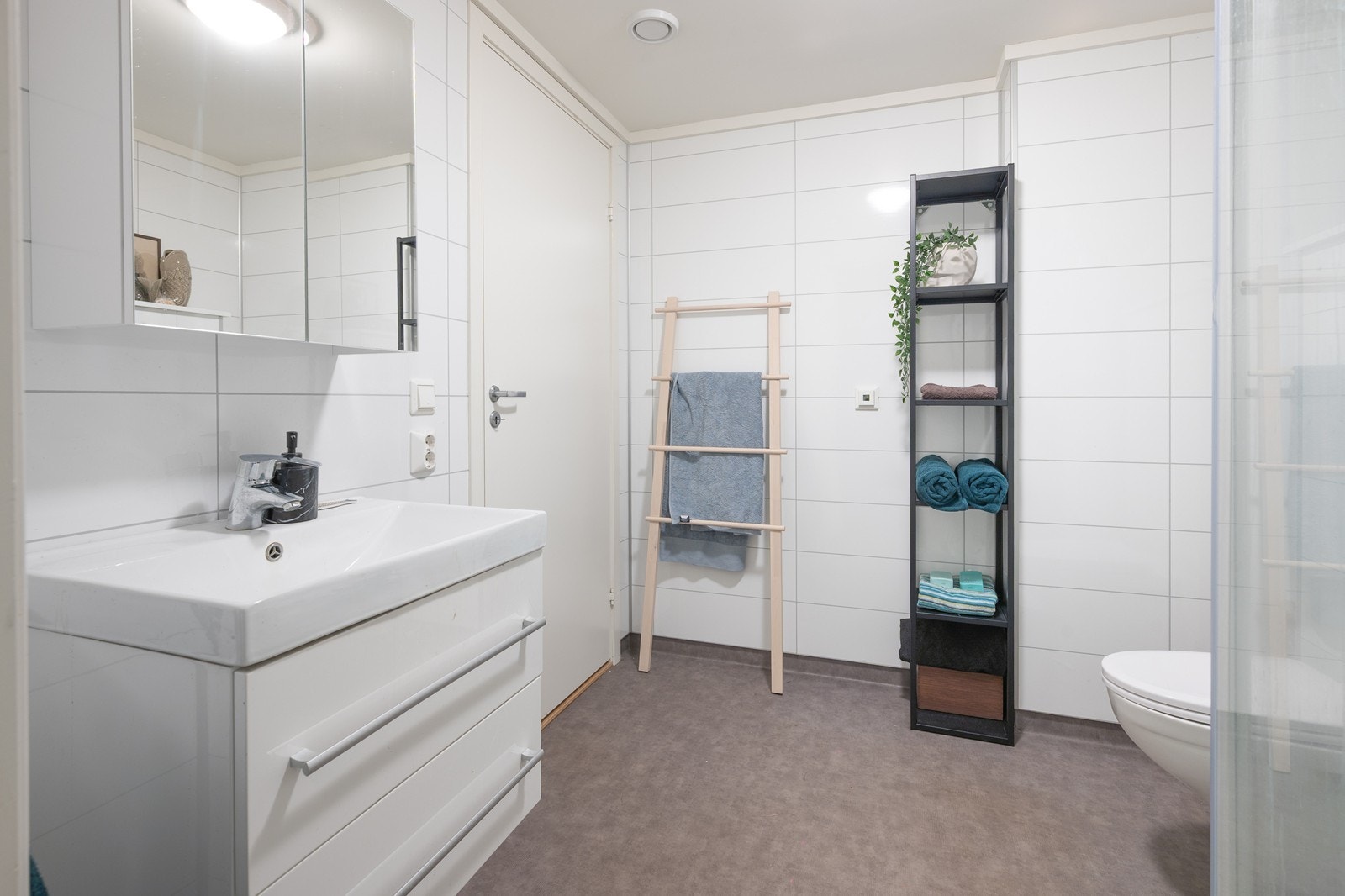 Pent bad med varmekabler, servantskap og overskap med speil Galleribilde