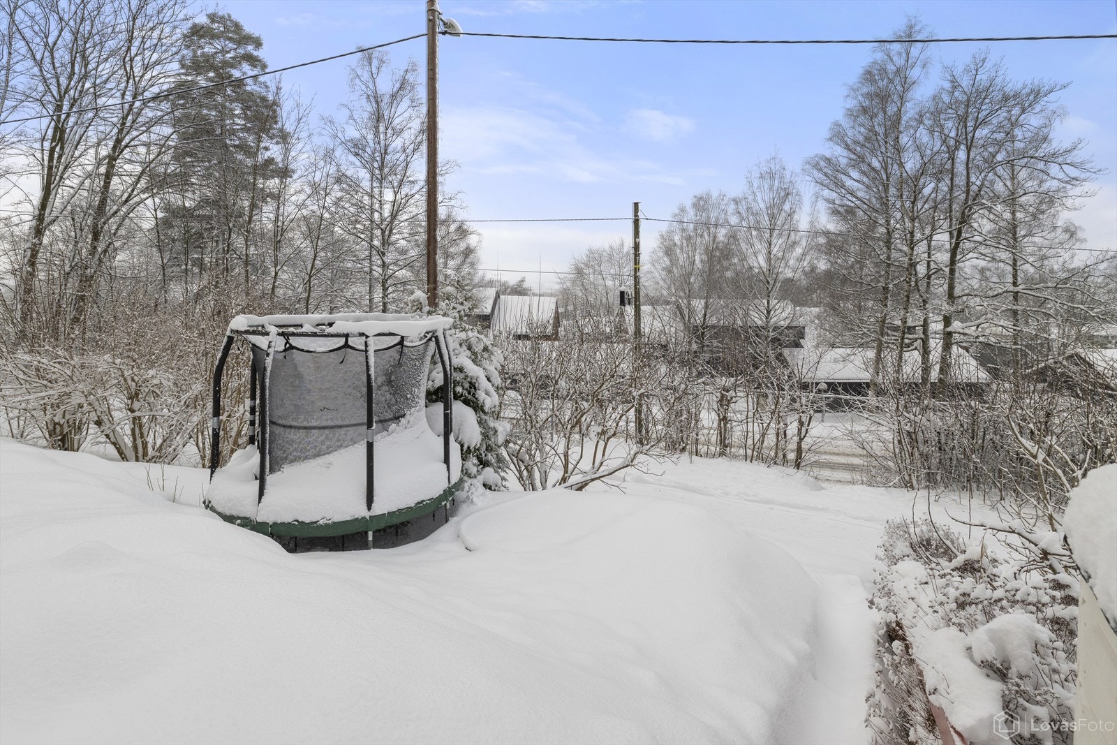 Nedenfor terrassen er en liten hage med bolomster- og urtekasser samt plass til trampoline. Gangveien nedenfor går rett opp til marka. Galleribilde